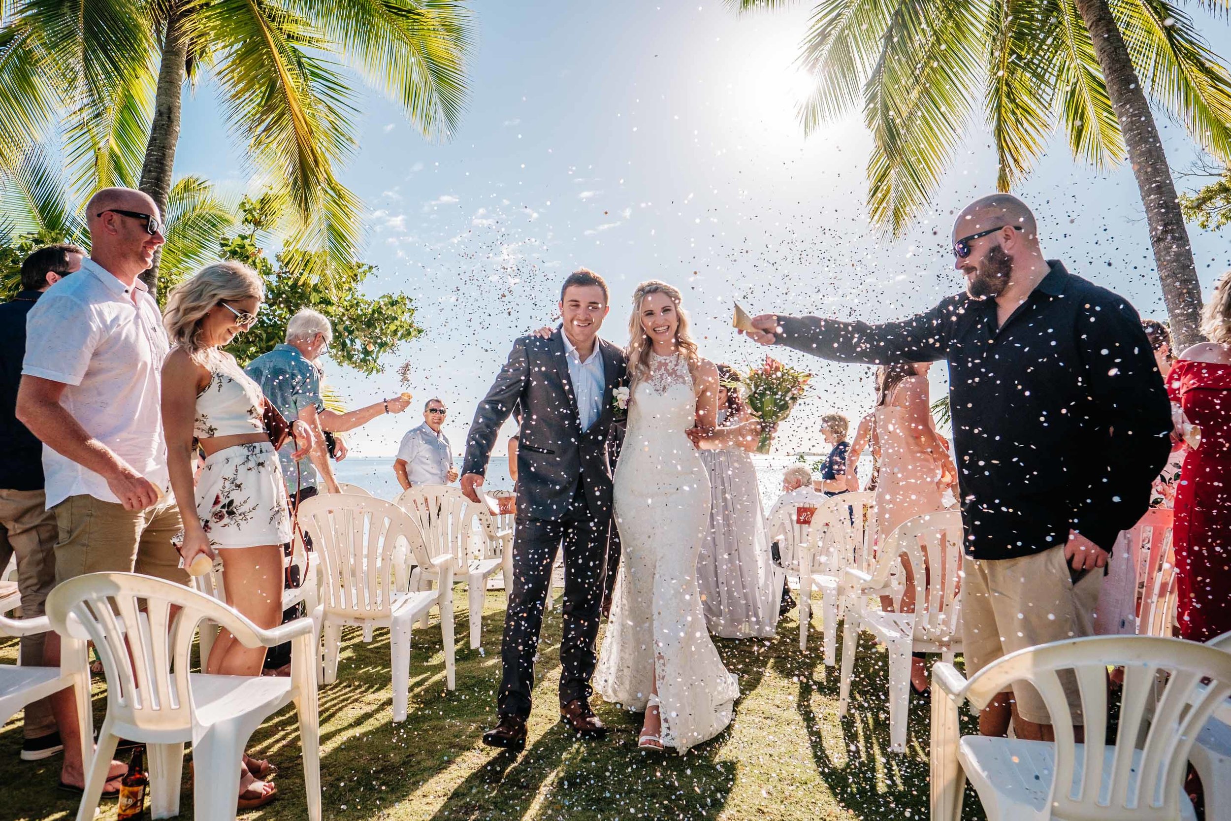 the newlyweds are showered in confetti as they walk down the aisle arm in arm