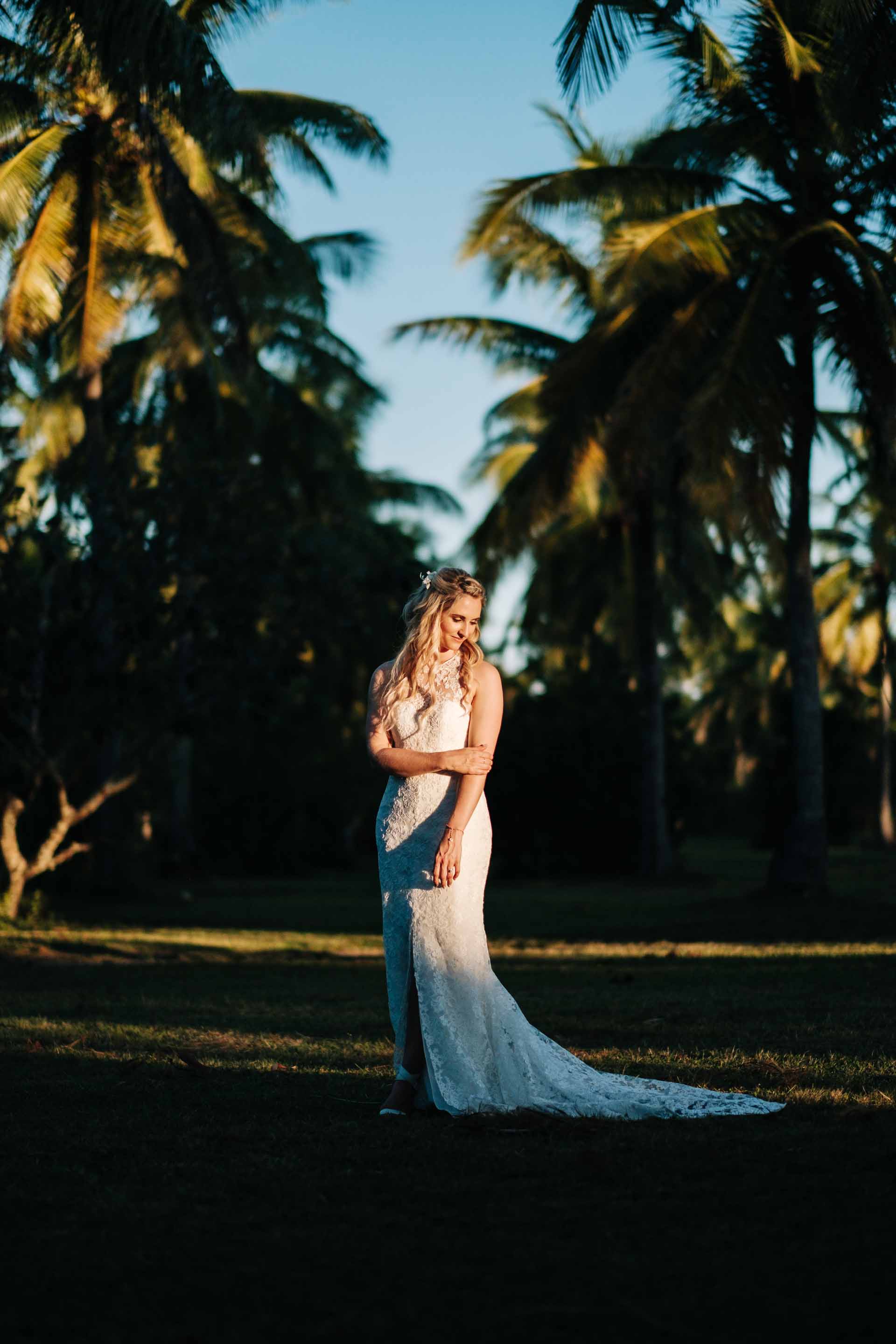 full length portrait of the bride between rows of coconut trees