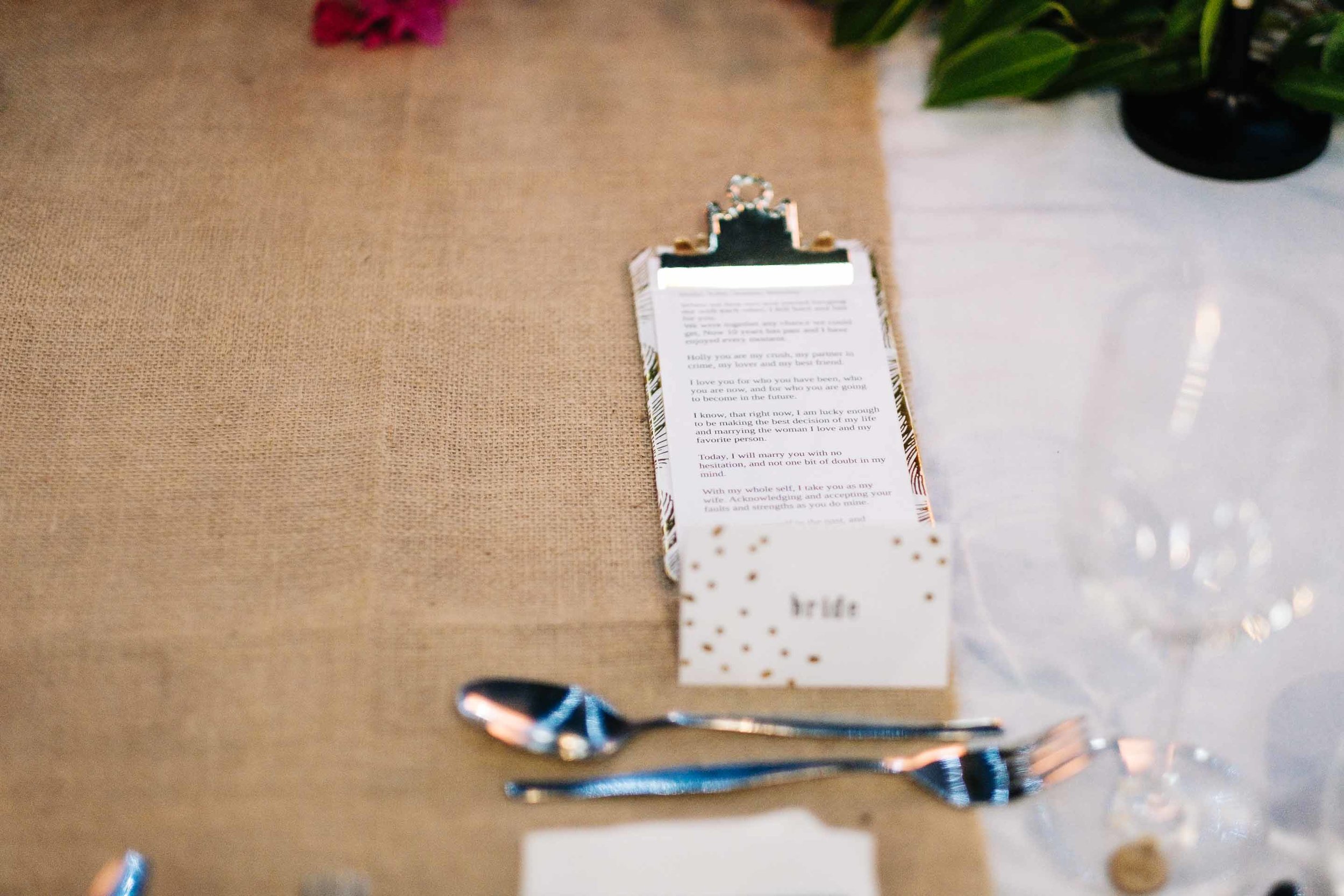 the grooms vows on his custom clipboard on the bridal table