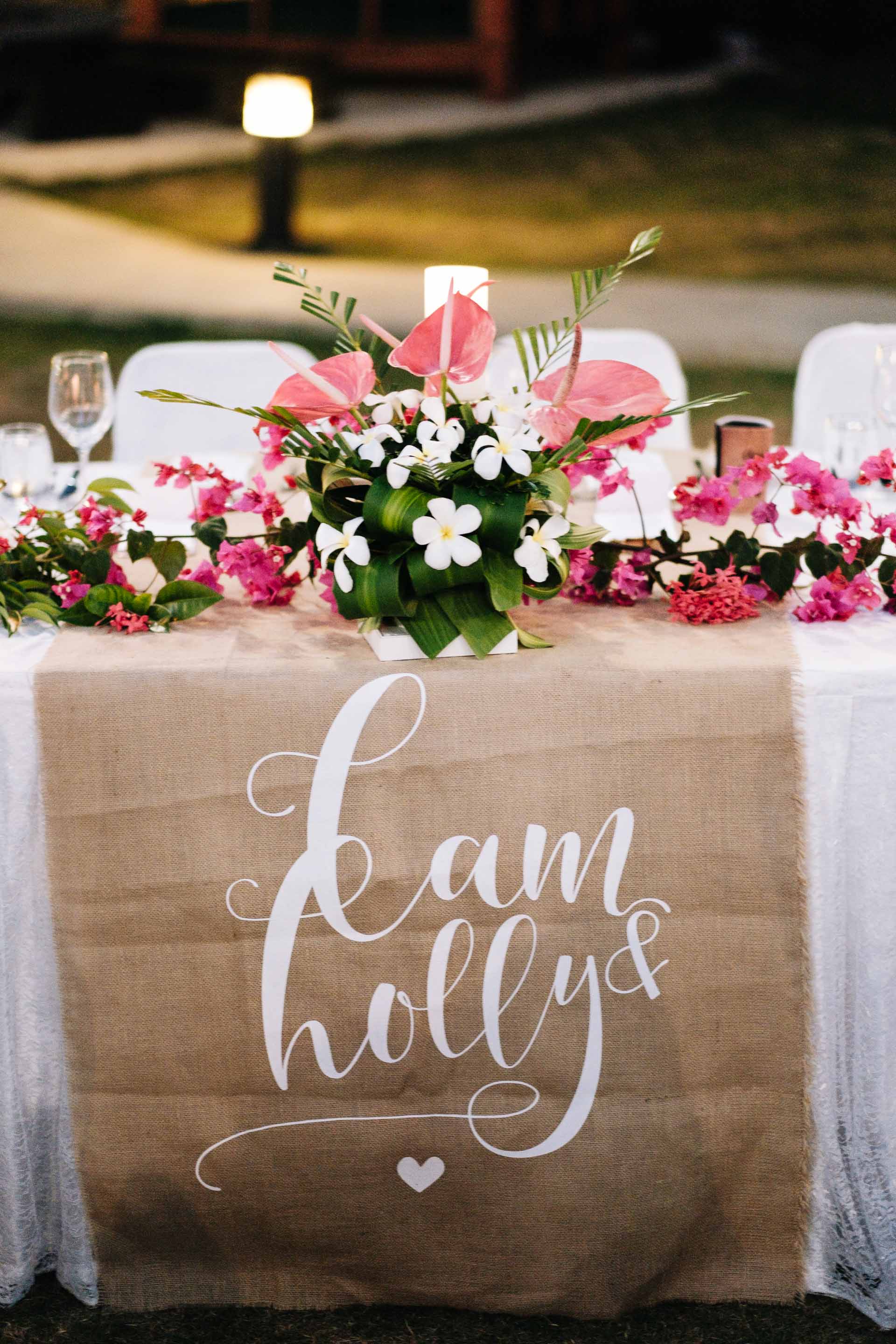 the head table with a burlap table runner printed with the bride and grooms names