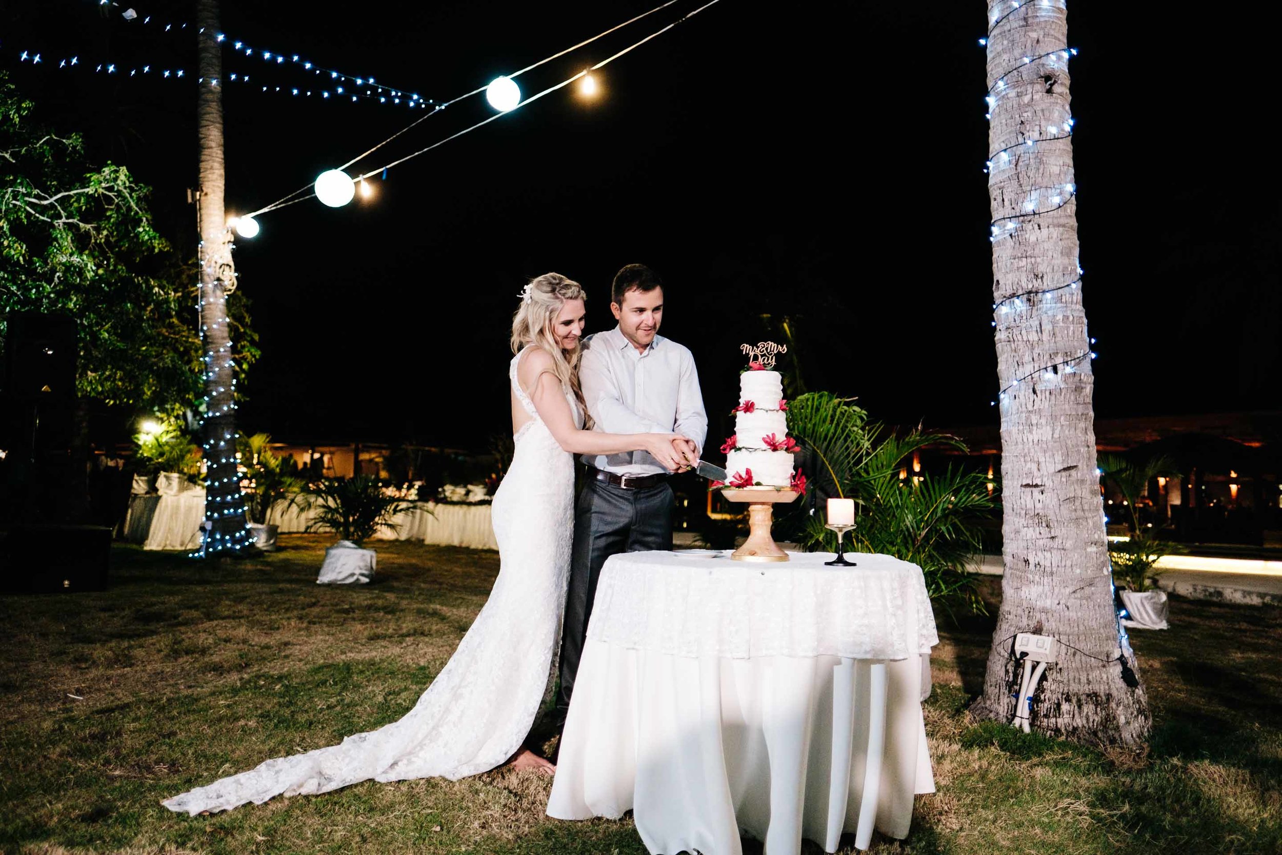 the bride and groom cutting their wedding cake