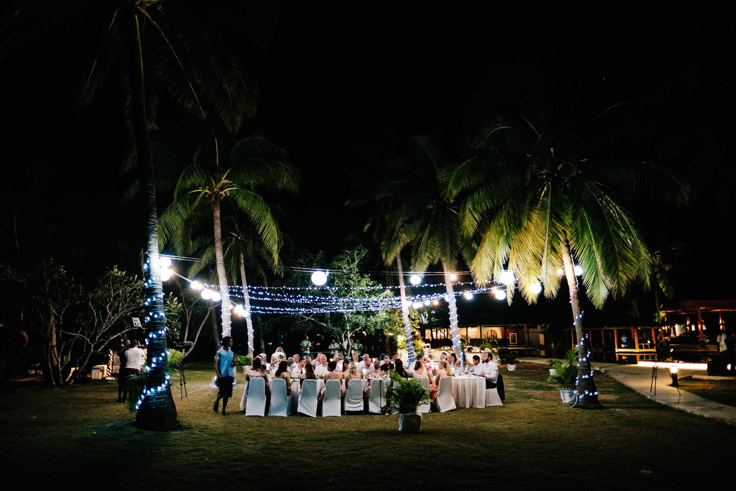 the wedding reception held under the trees by the beach at Lomani Island Resort
