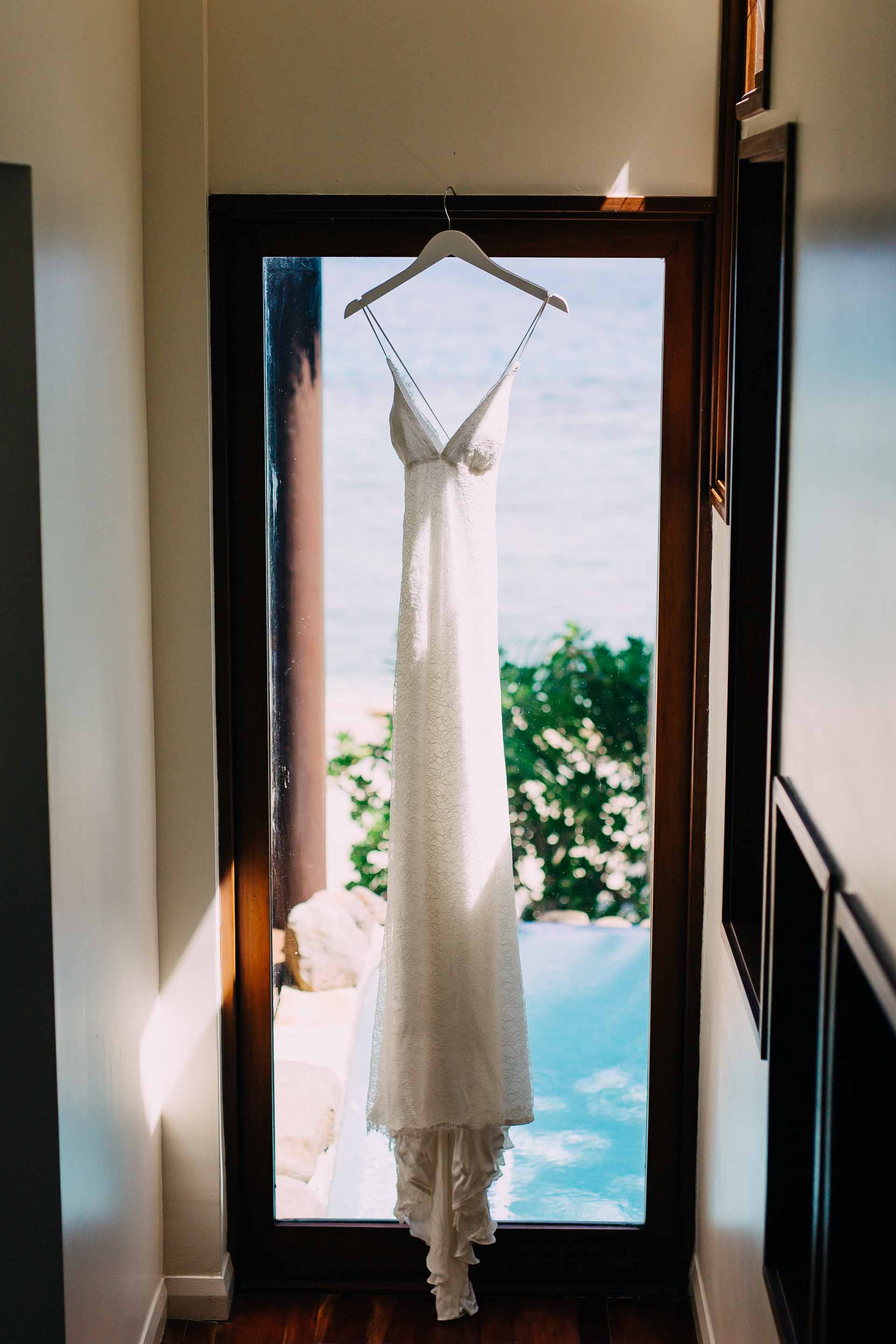Fiji Bride's wedding dress hangs in the doorway of the beautiful villa. 