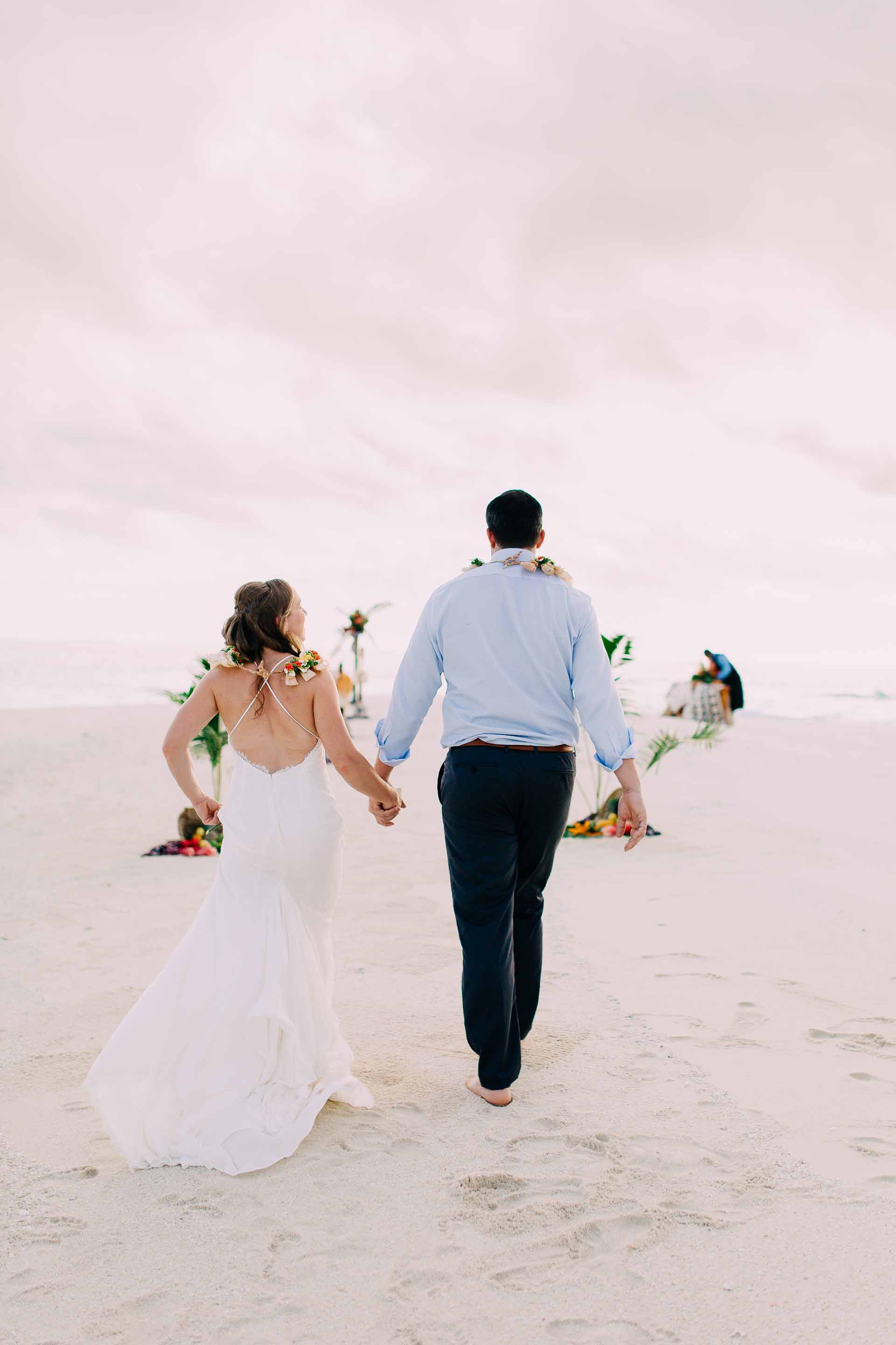 Bride and Groom walk up the aisle to exchange vows at their sand bar wedding.