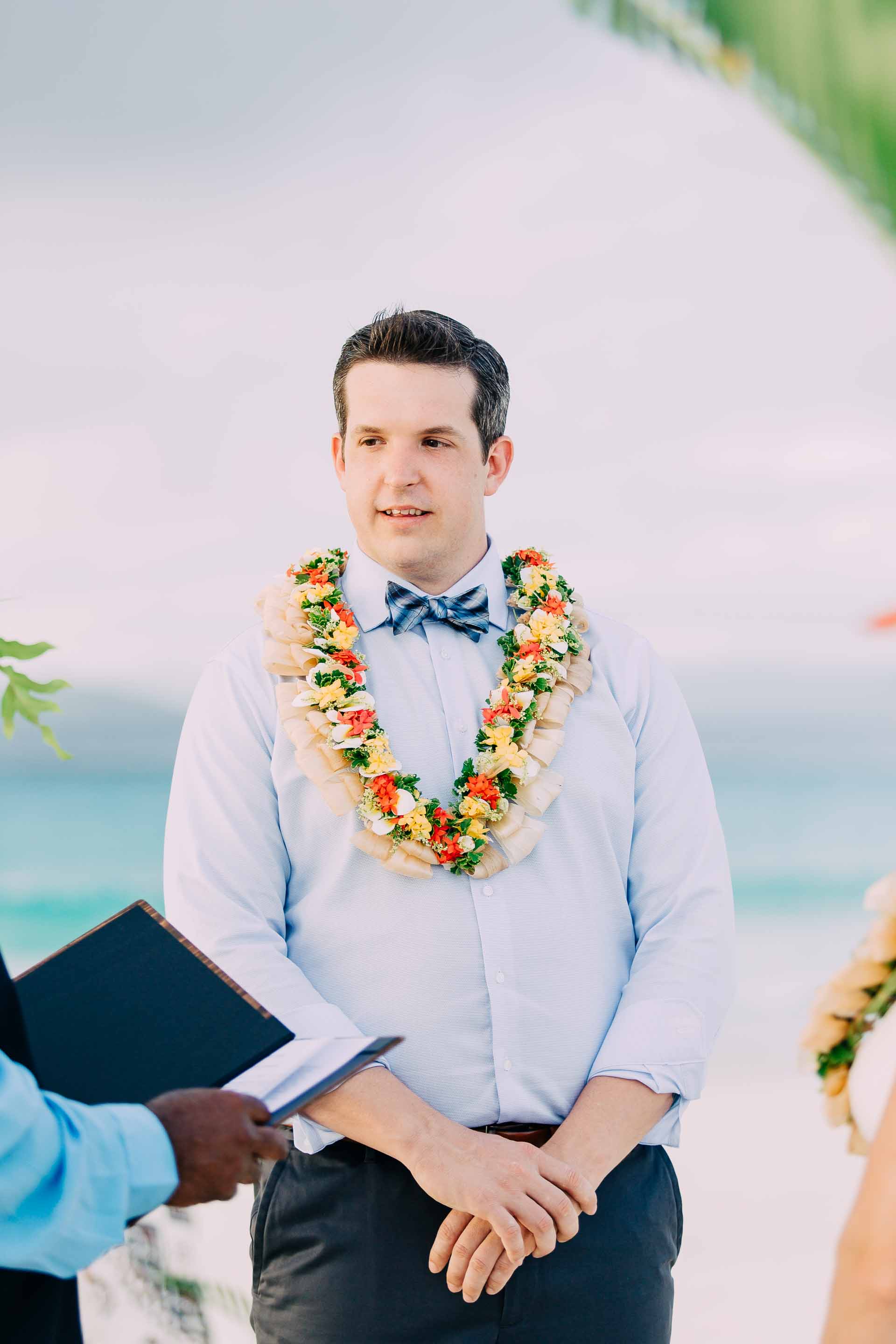 Emotional Groom says his vows during his Fiji elopement on a sand bar in the ocean.