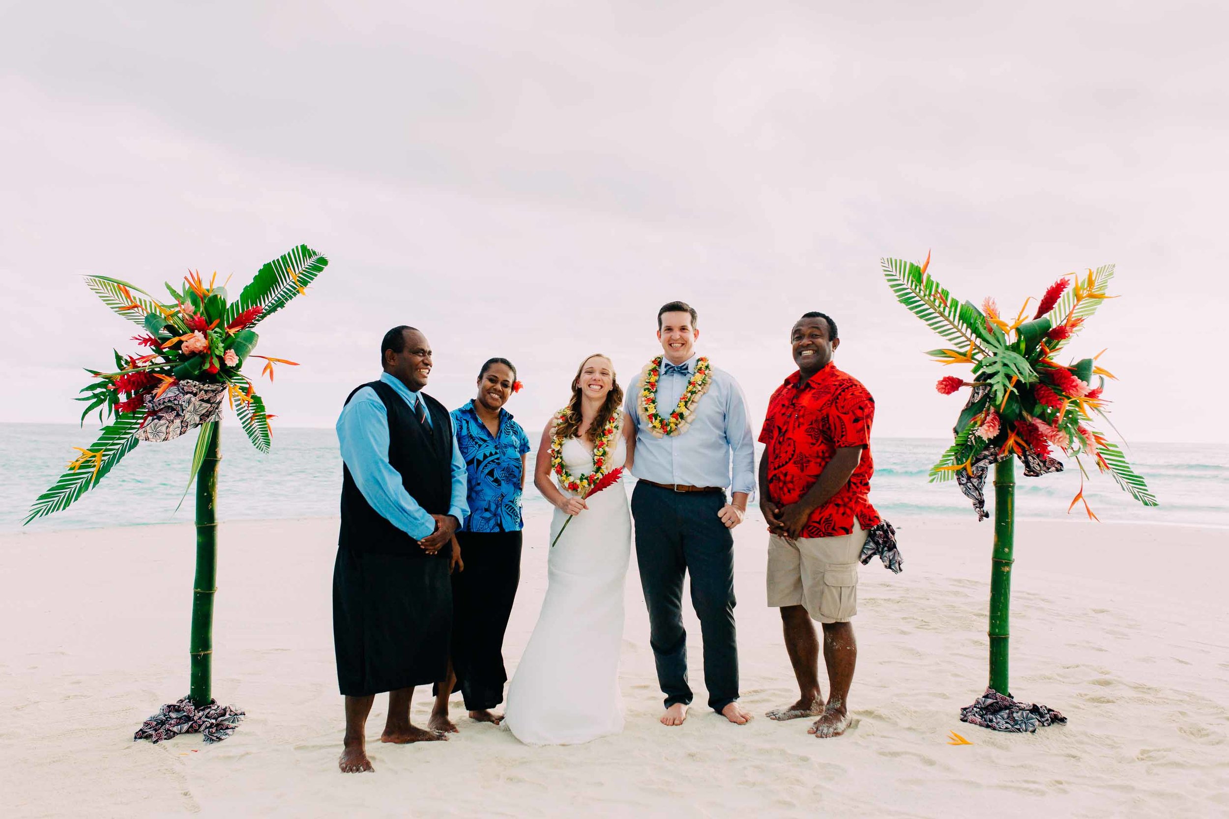 Royal Davui staff pose with the happy newlyweds on the sand quay after the ceremony.