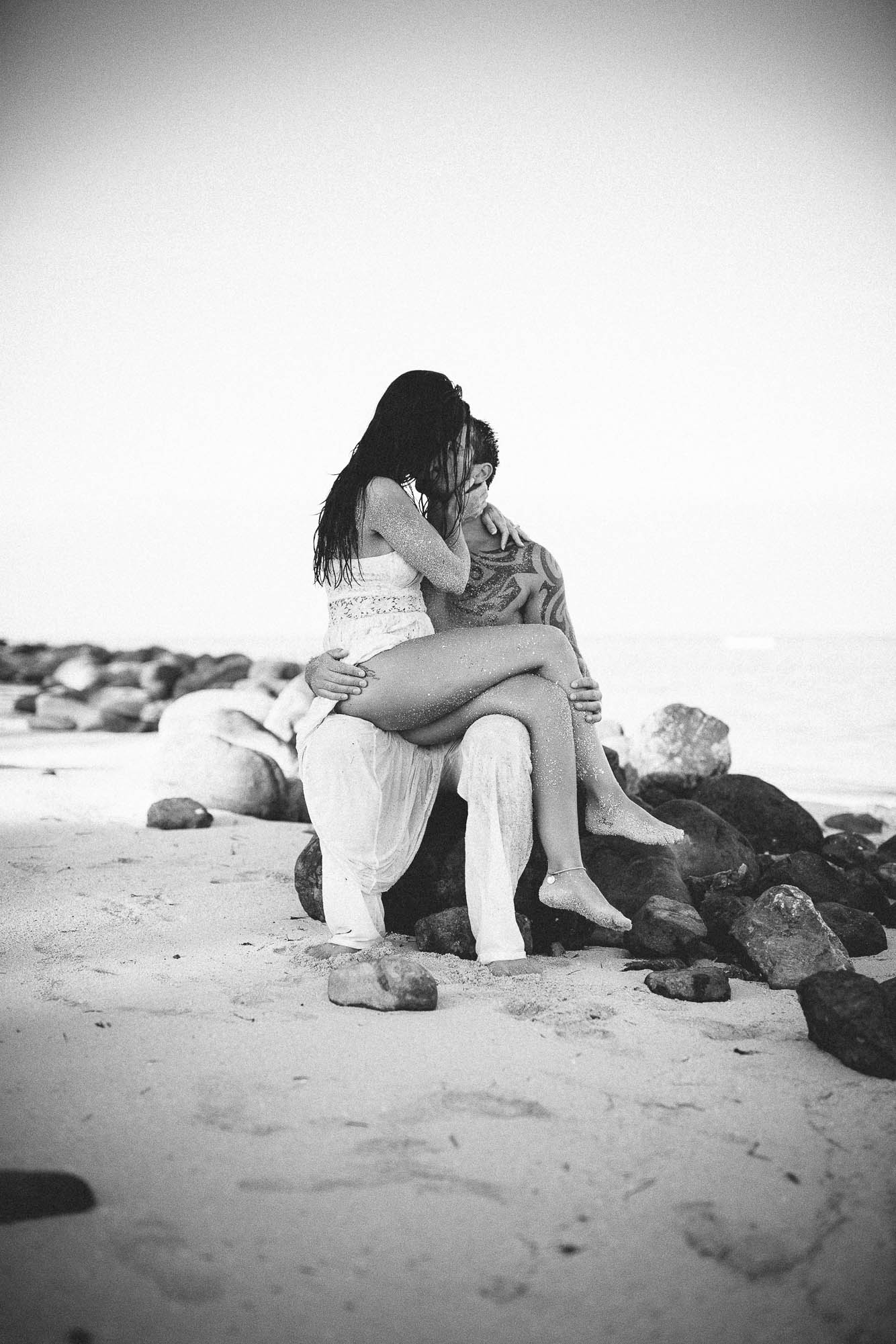 bride sitting on grooms lap kissing