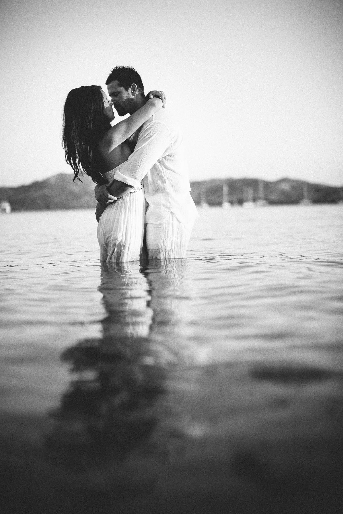 bride and groom hugging in the water