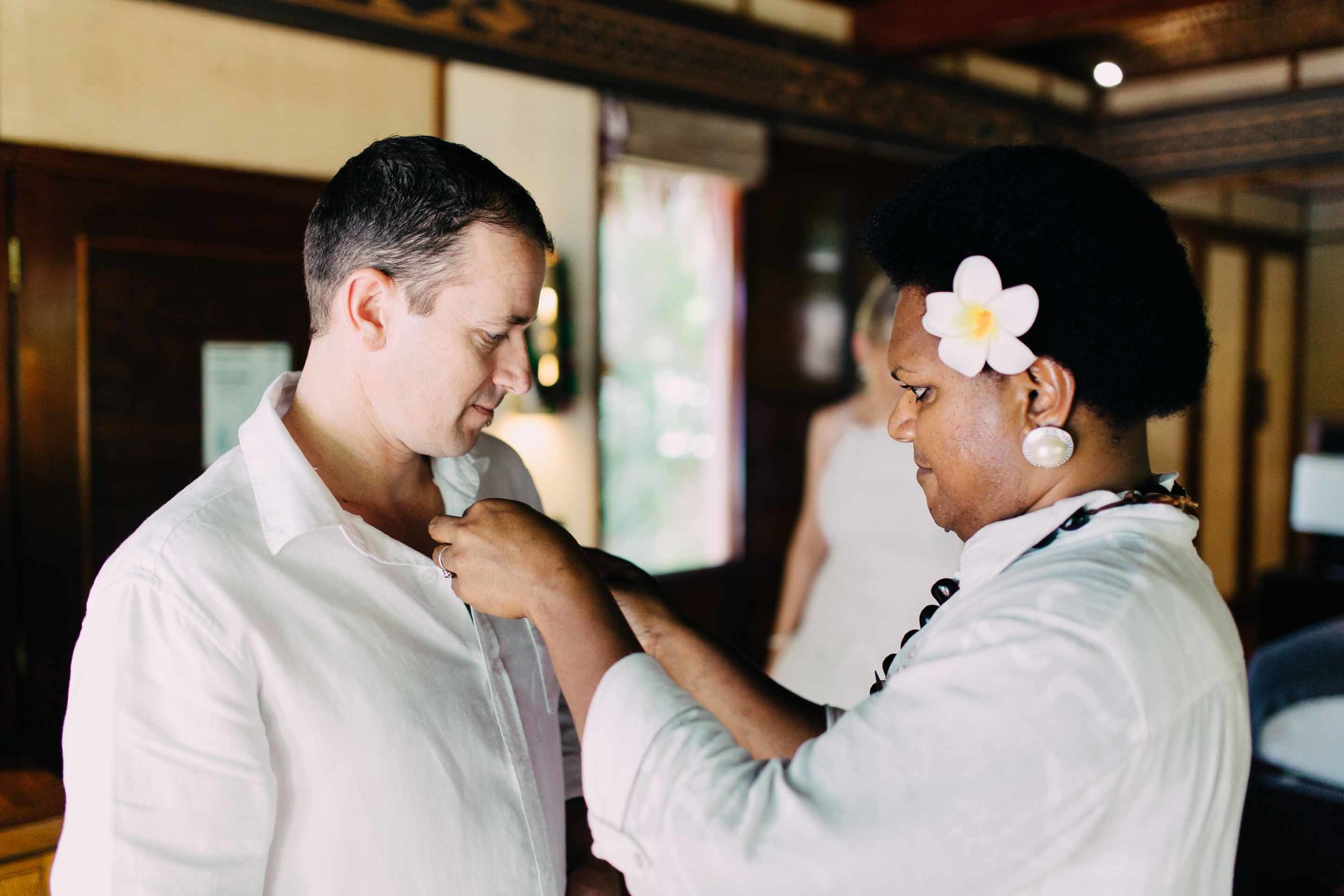 the groom getting help with his boutonnière