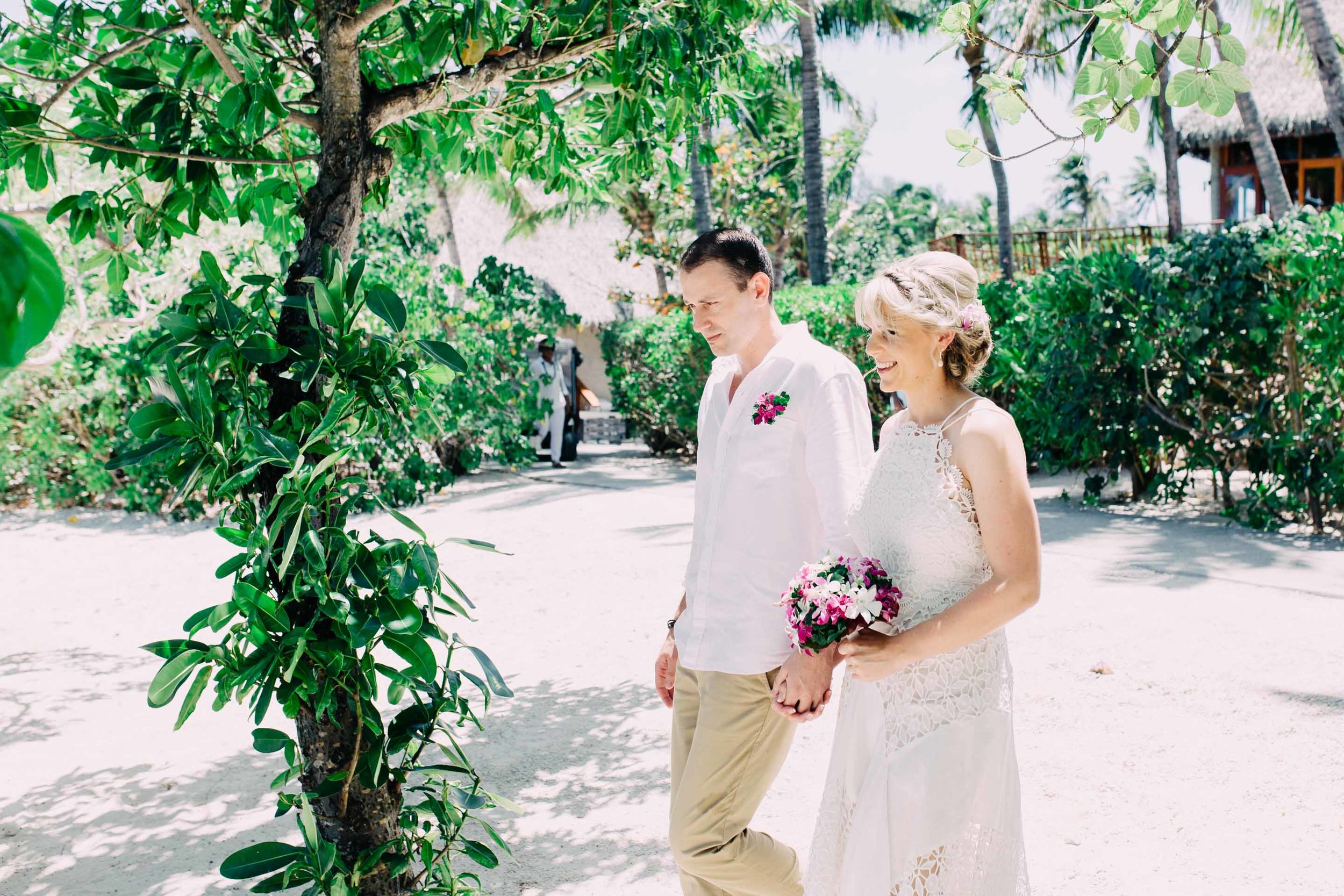 the bride and groom walking hand in hand down the sand aisle to their wedding ceremony