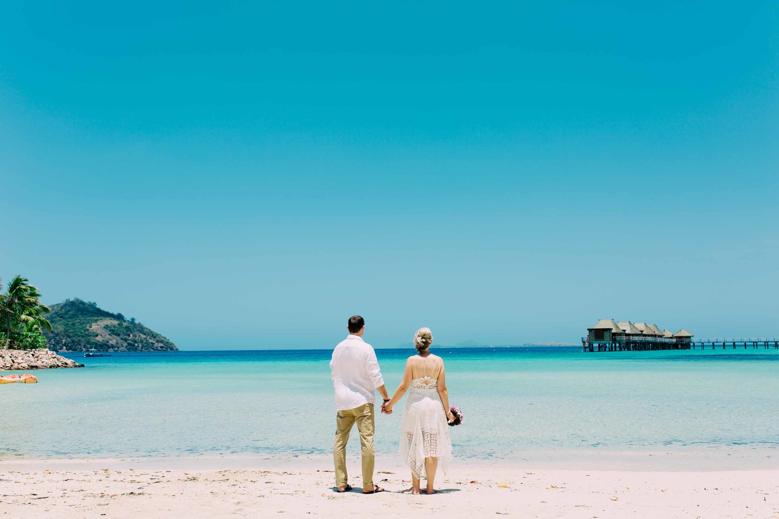 the couple hand in hand looking out to Qalito island home of Castaway Island Resort