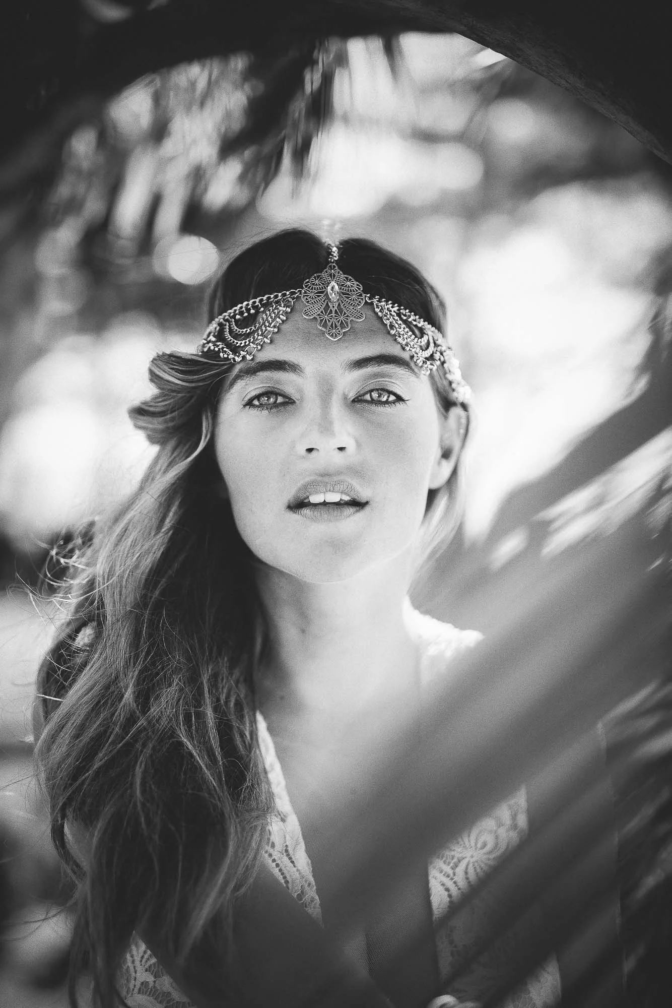 model looking through palm fonds
