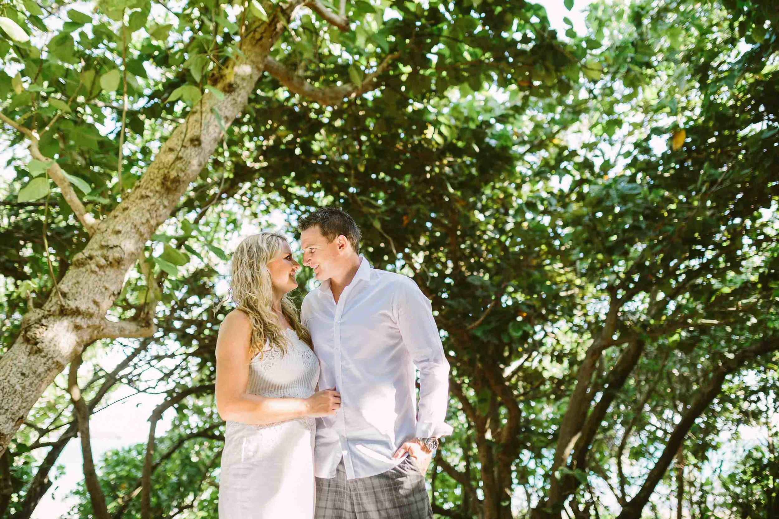 bride and groom kissing under the trees