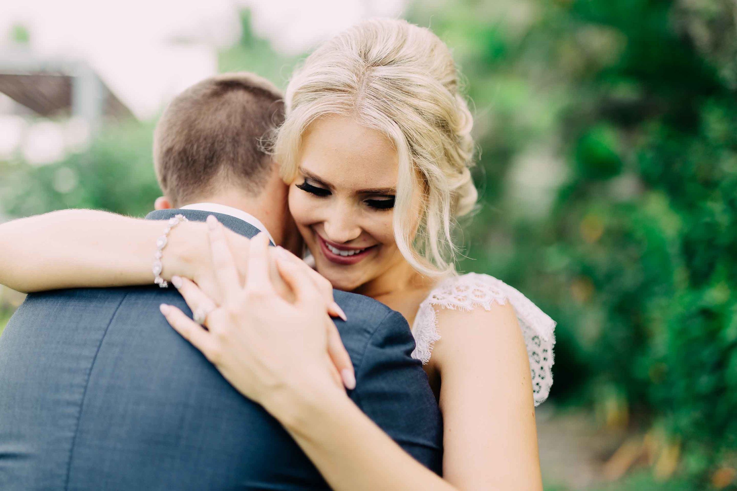 A cute moment between the newlyweds smily bride embraces her new husband.