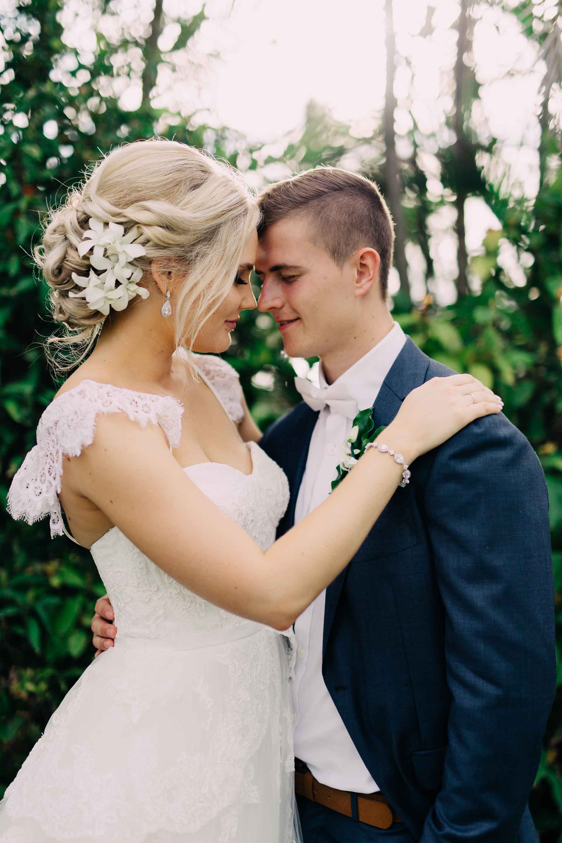 Newlyweds touch foreheads and smile.