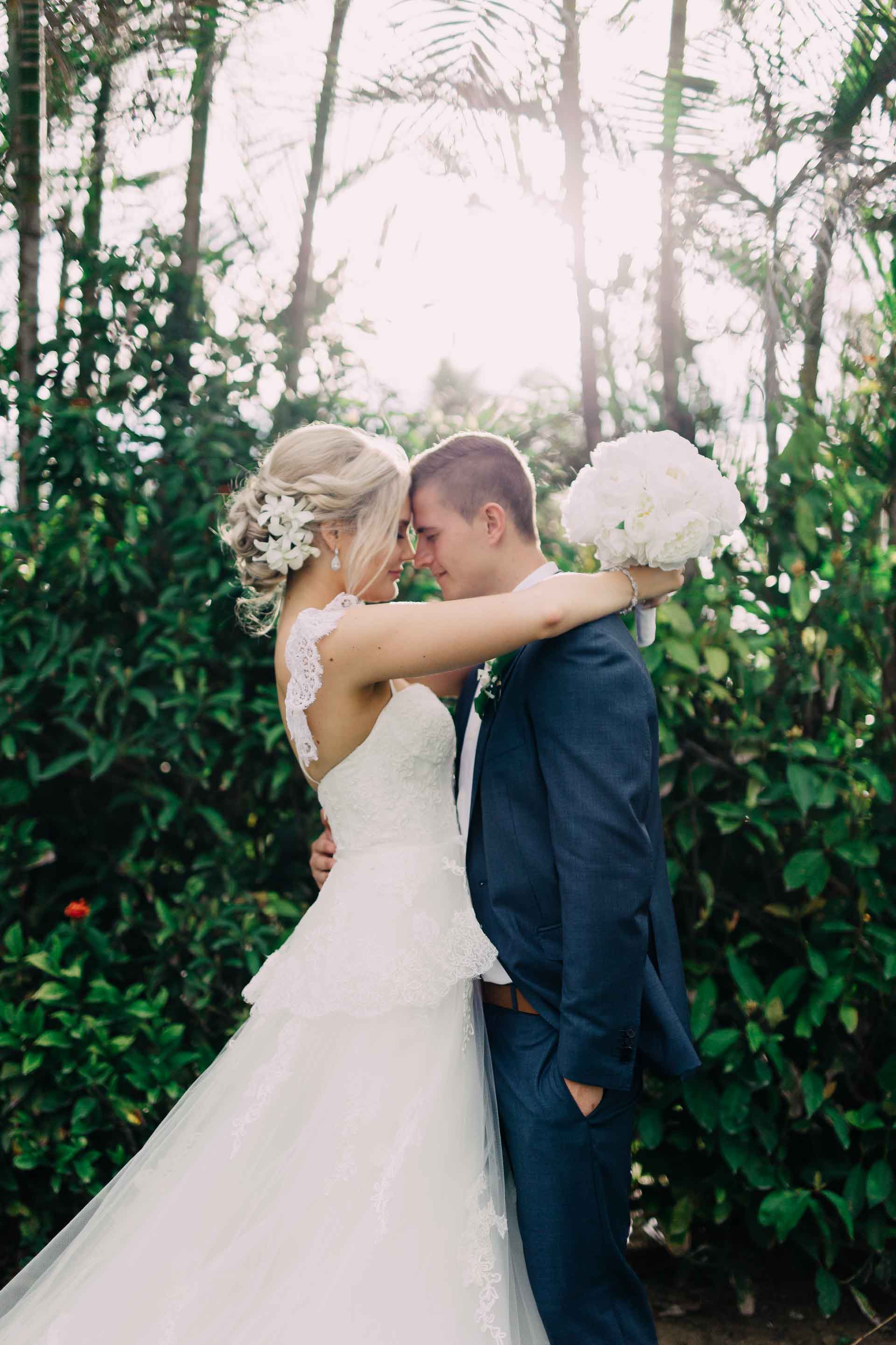 Stunning portrait of bride and groom beautiful white wedding dress and classic blue wedding suit tropical Fiji wedding at the Hilton.