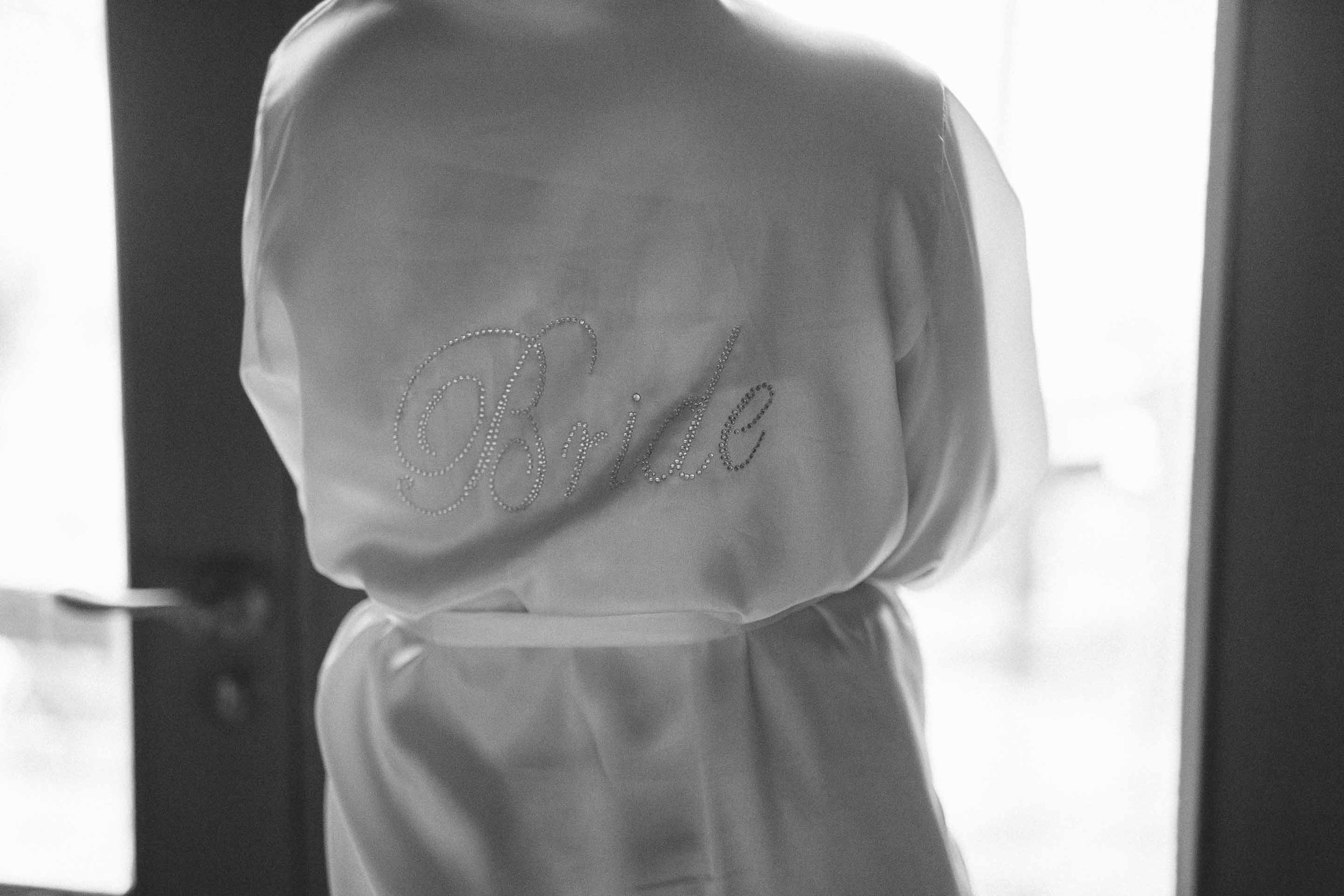 the bride in her robe with the word bride on the back