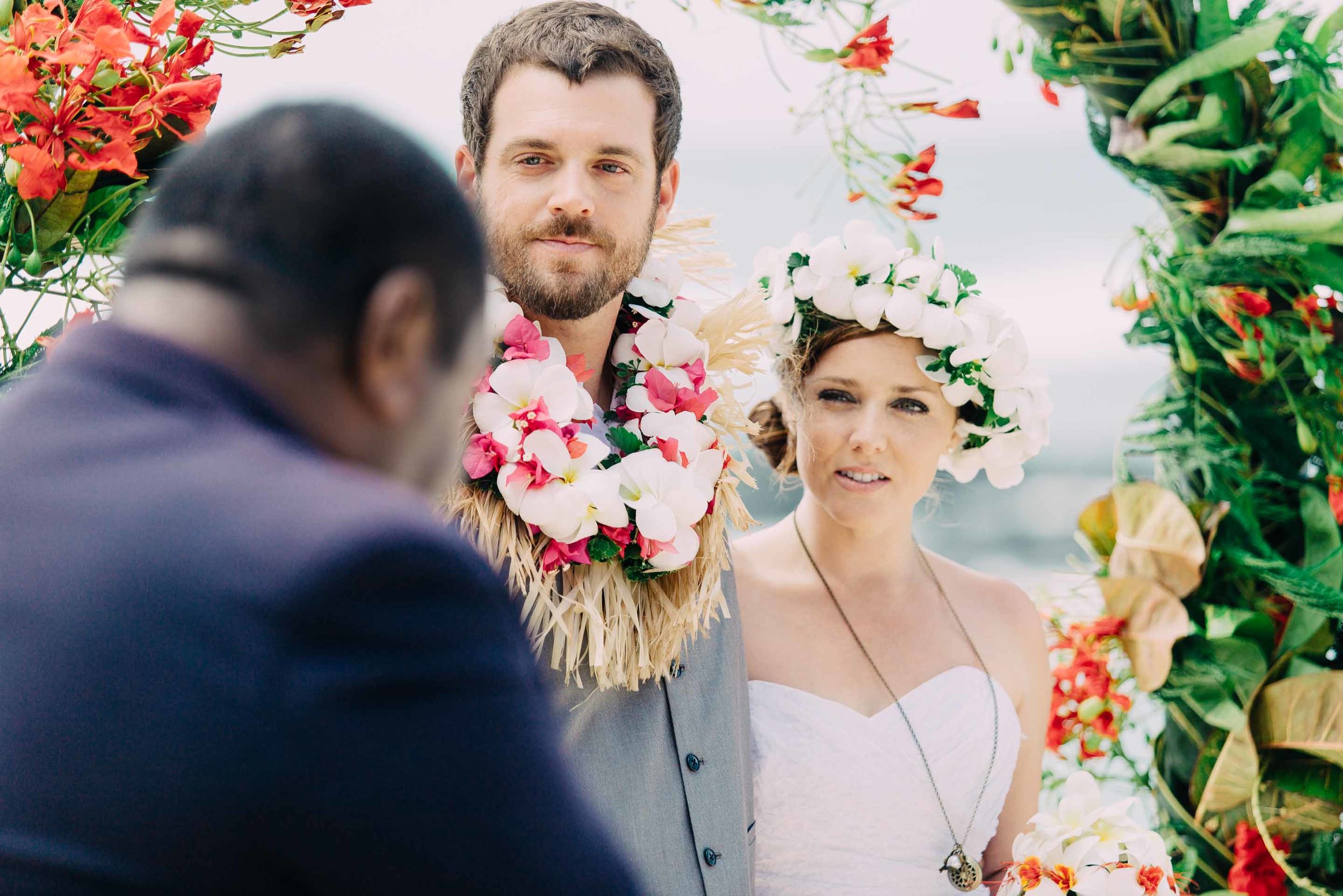 the bride and groom listening to the priest during their wedding ceremony