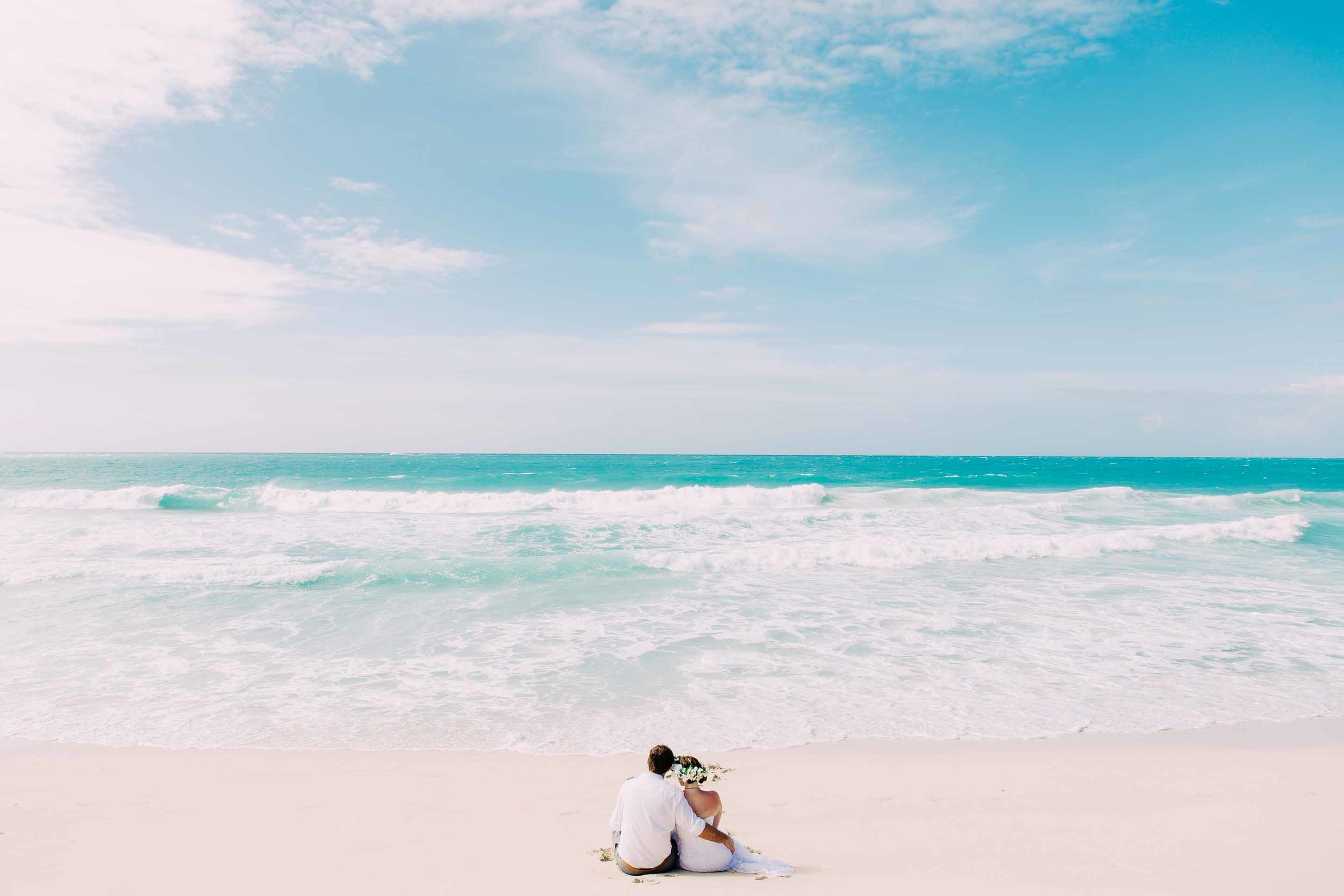 the couple sitting alone on the deserted beach