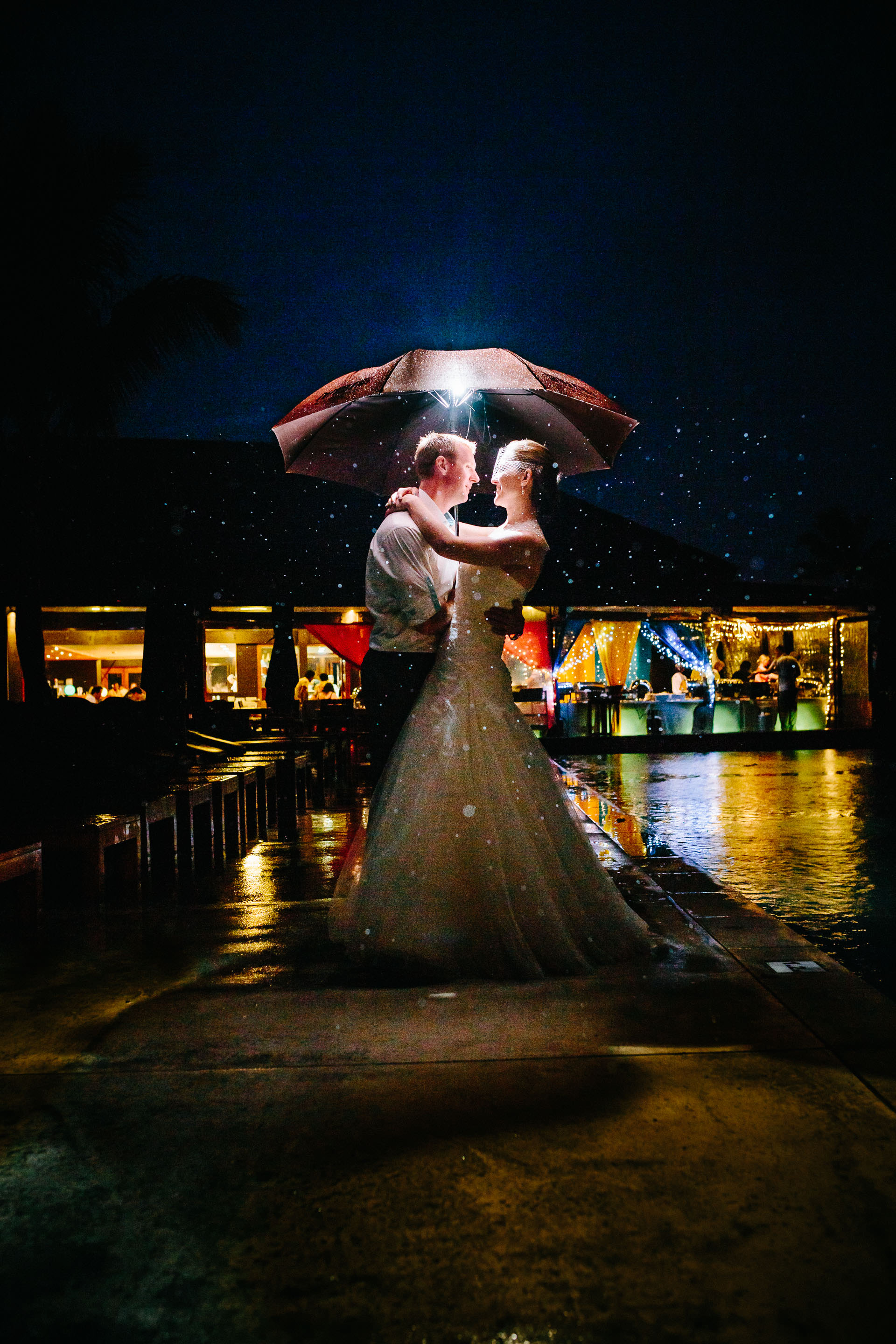 Night portrait of the newlyweds under an umbrella