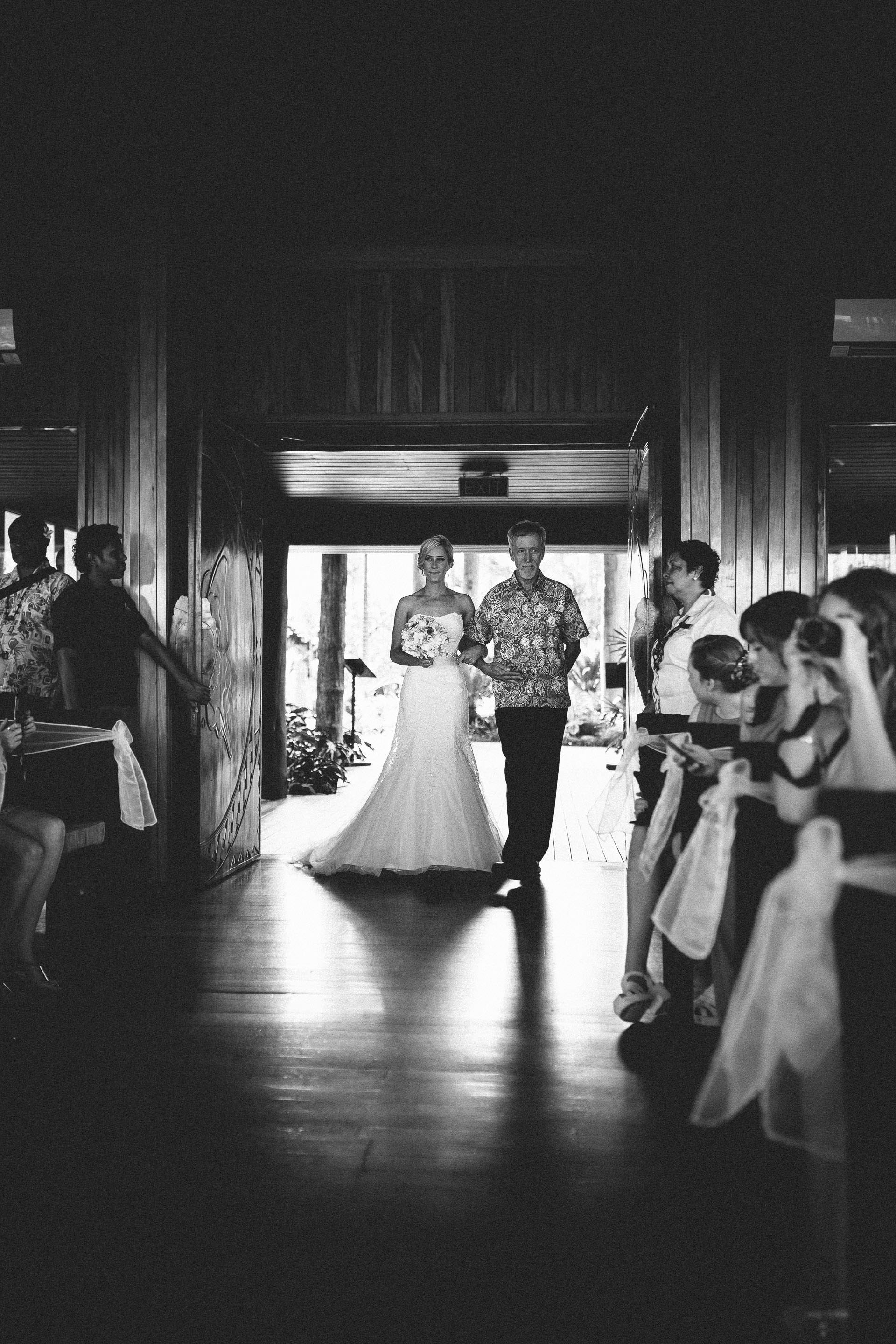 Bride being walked down the aisle by her father, black and white