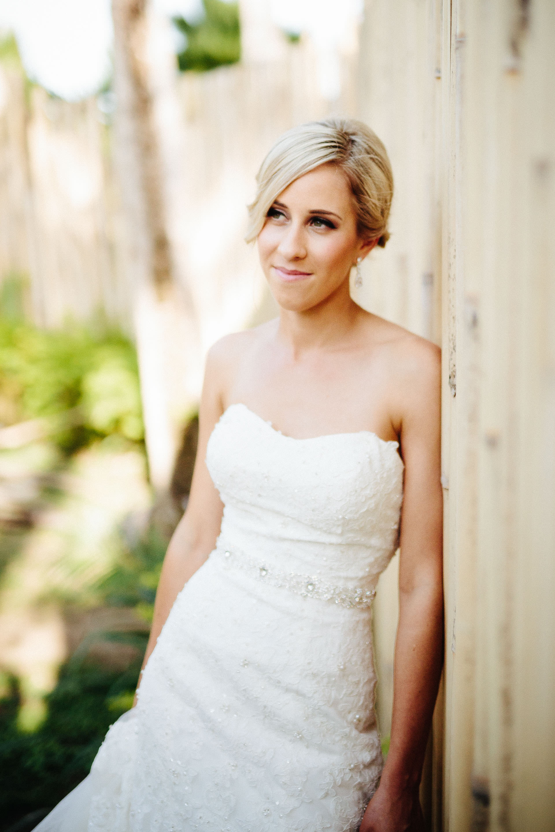 bride leaning against bamboo fence