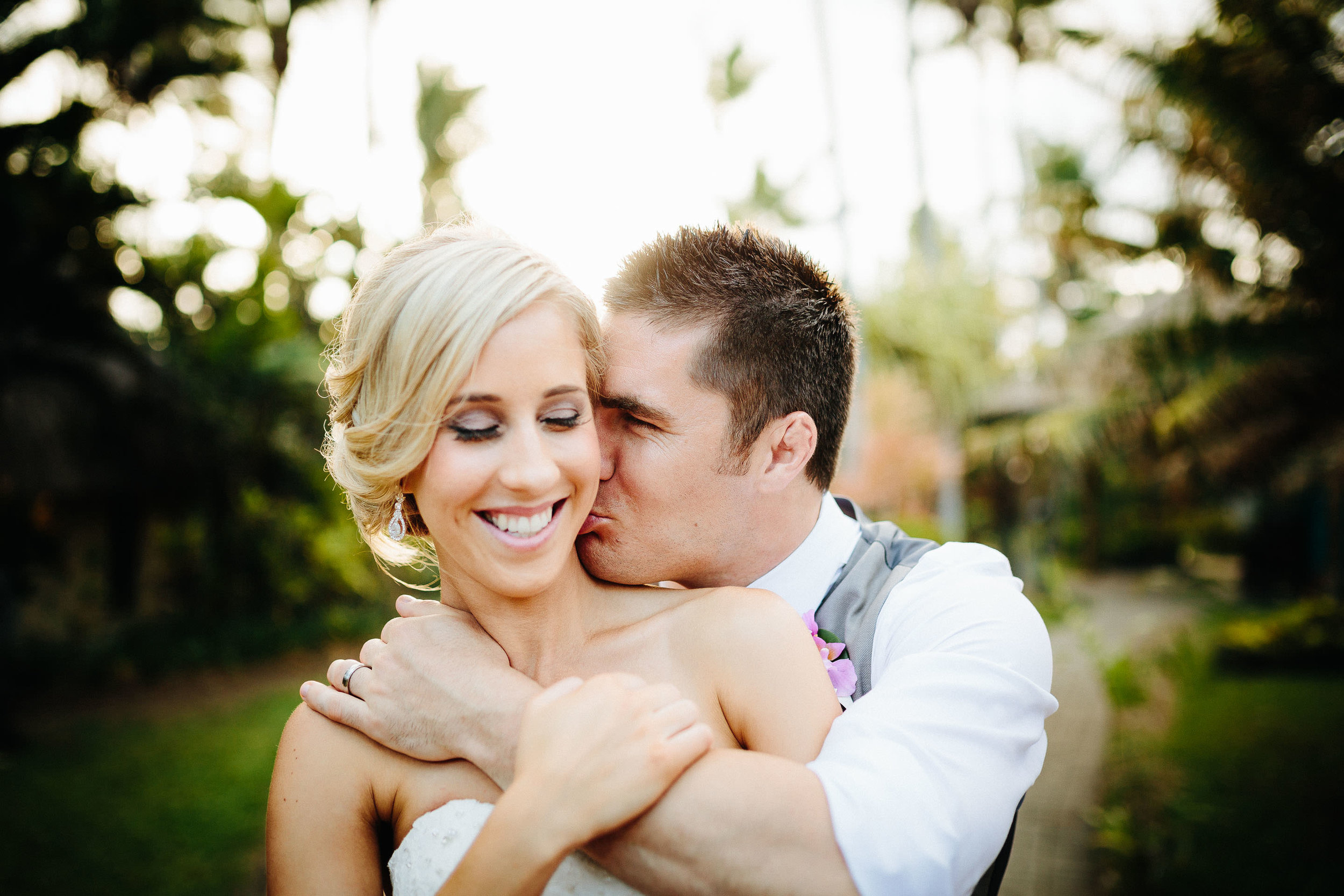 groom kissing bride on her neck