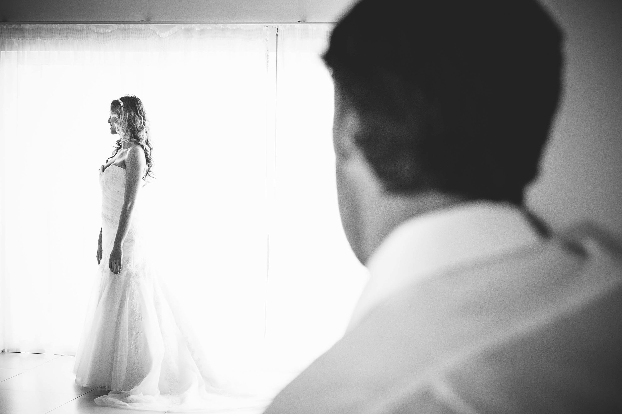 groom watching bride get ready