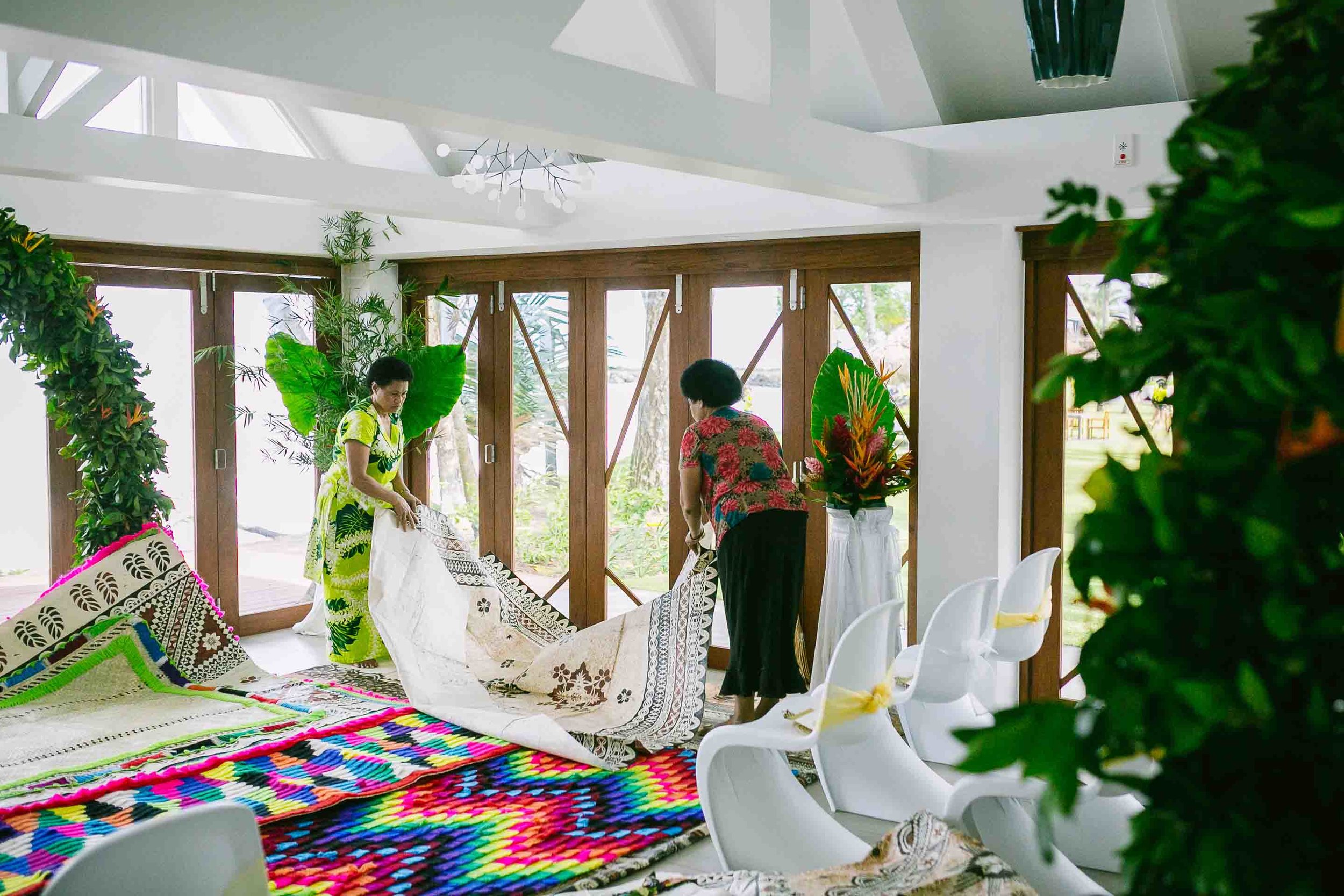 Mother of the bride helping lay traditional Fijian mats at the alter