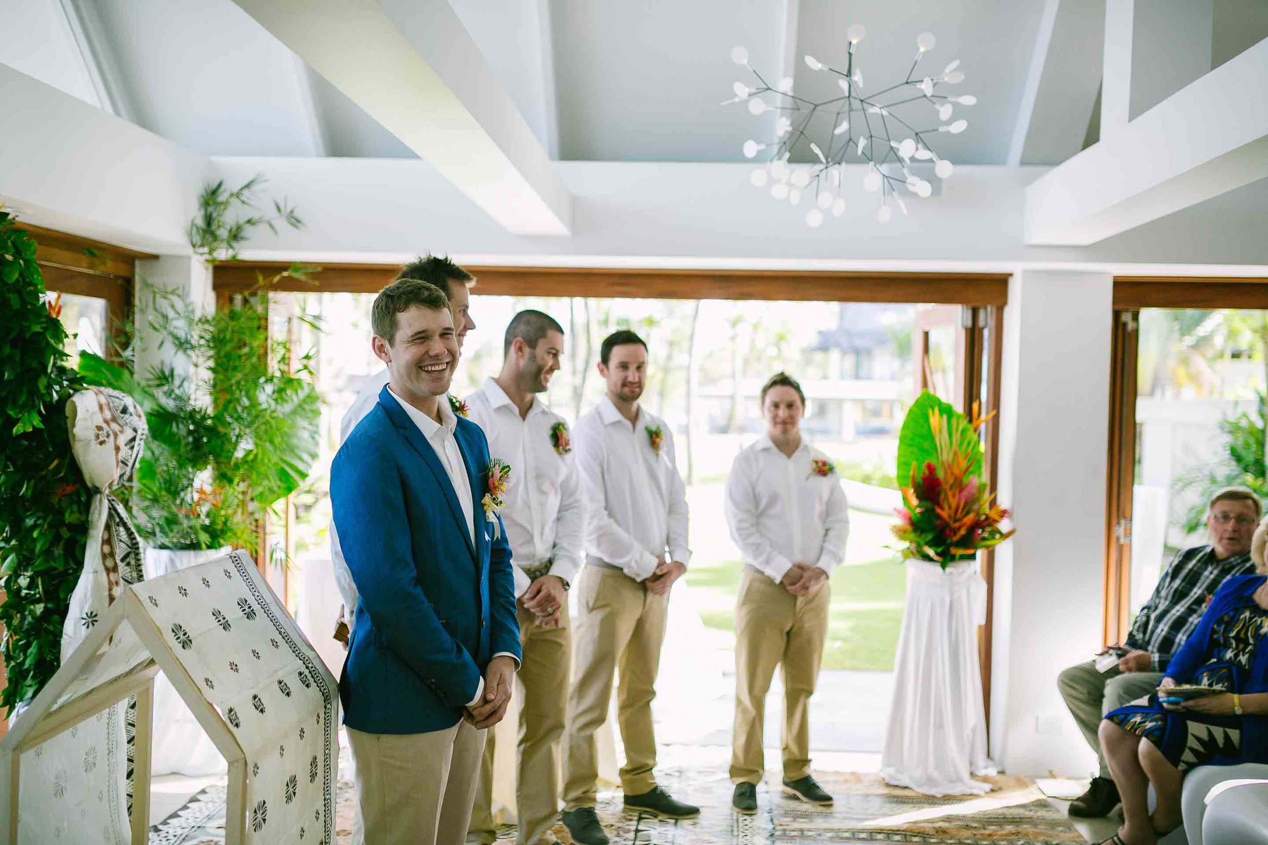 the groom and groomsman waiting at the end of the alter for his bride