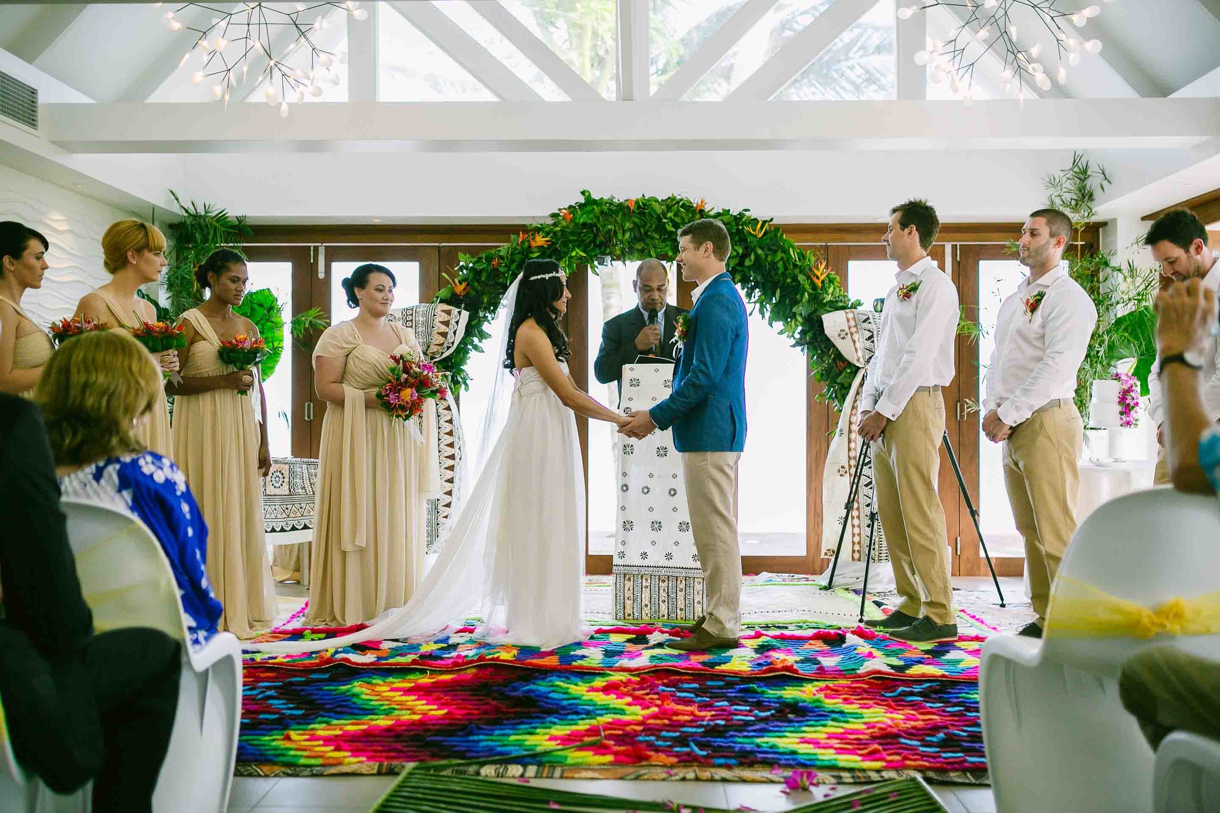 the bride and groom holding hand as the celebrant conducts the wedding ceremony