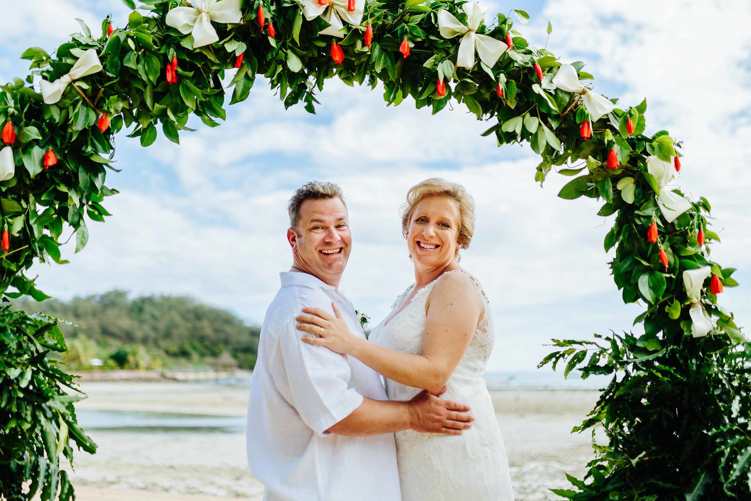 the couple under their wedding arch