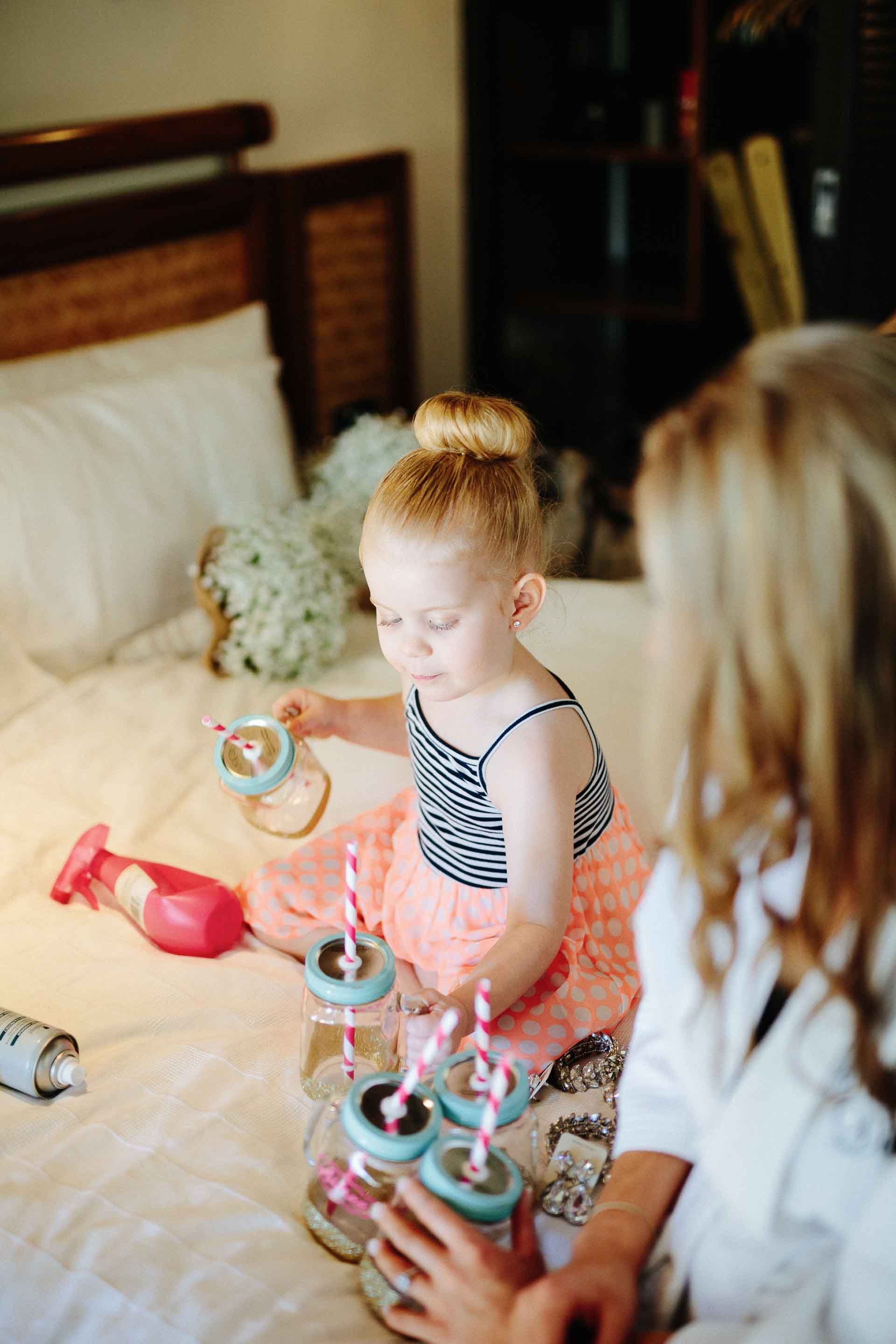 flower girl playing with the bridesmaids sippy cups