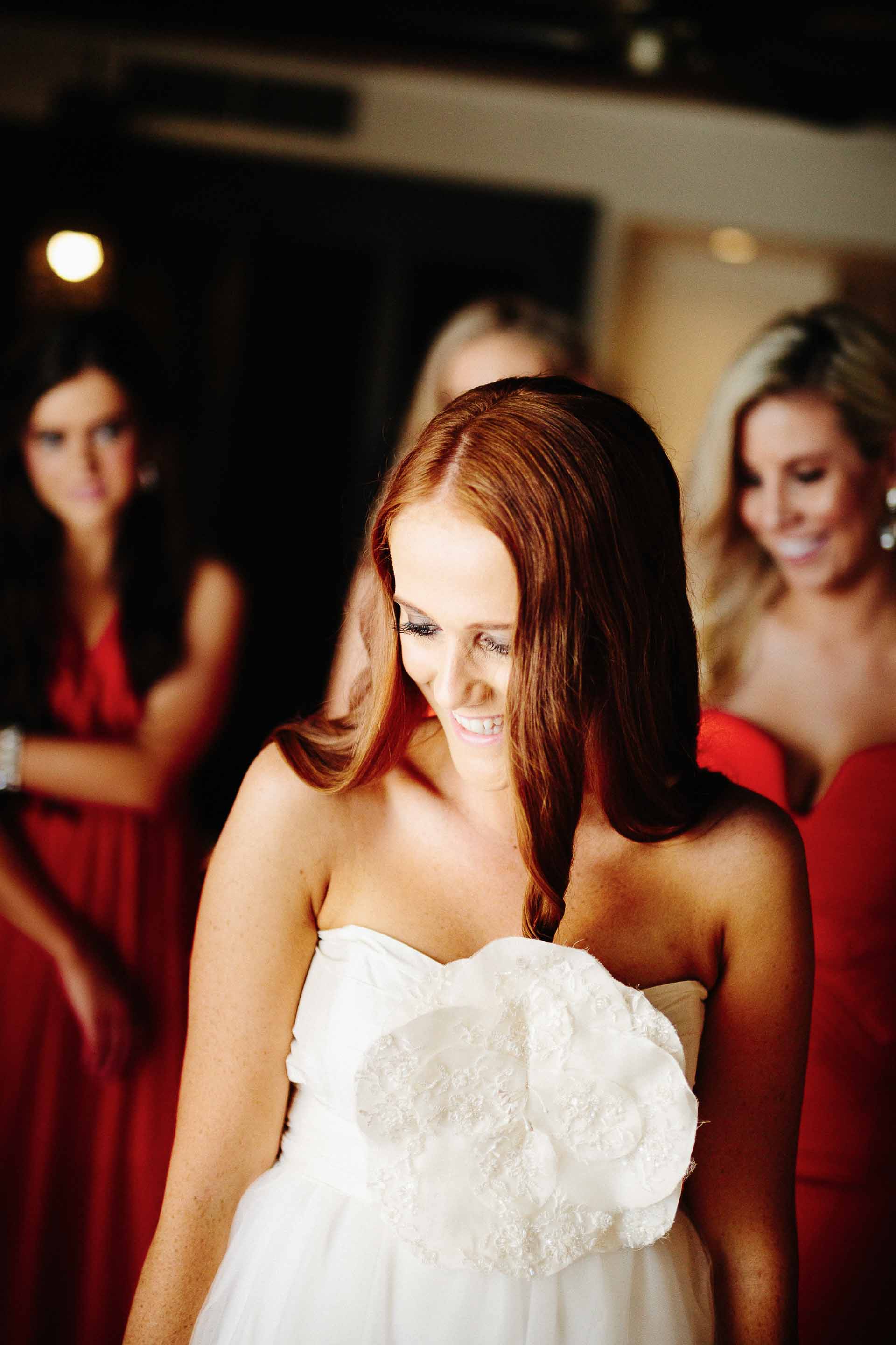 bridesmaids helping the bride into her dress