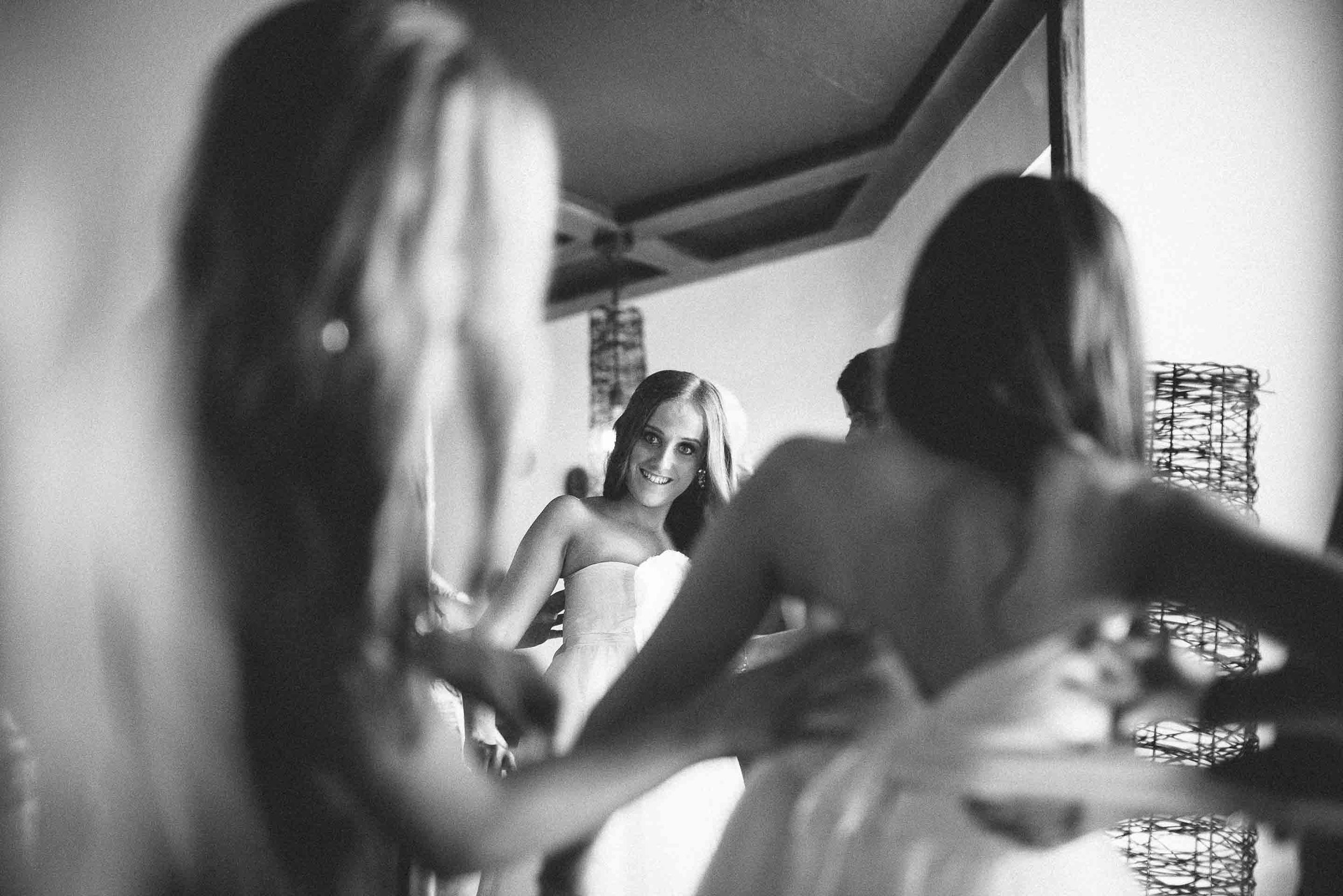 the finishing touches by the bridesmaids on the brides wedding gown