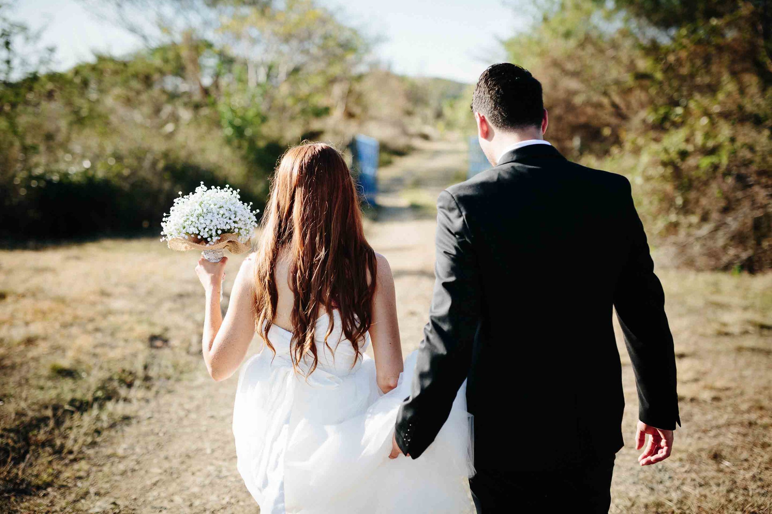 the groom helping his bride wth her dress