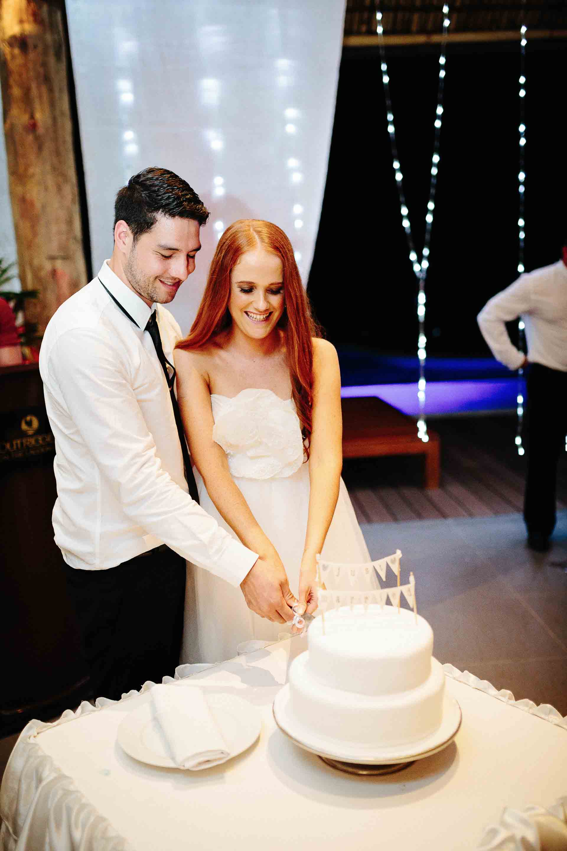 the bride and groom cutting their wedding cake together