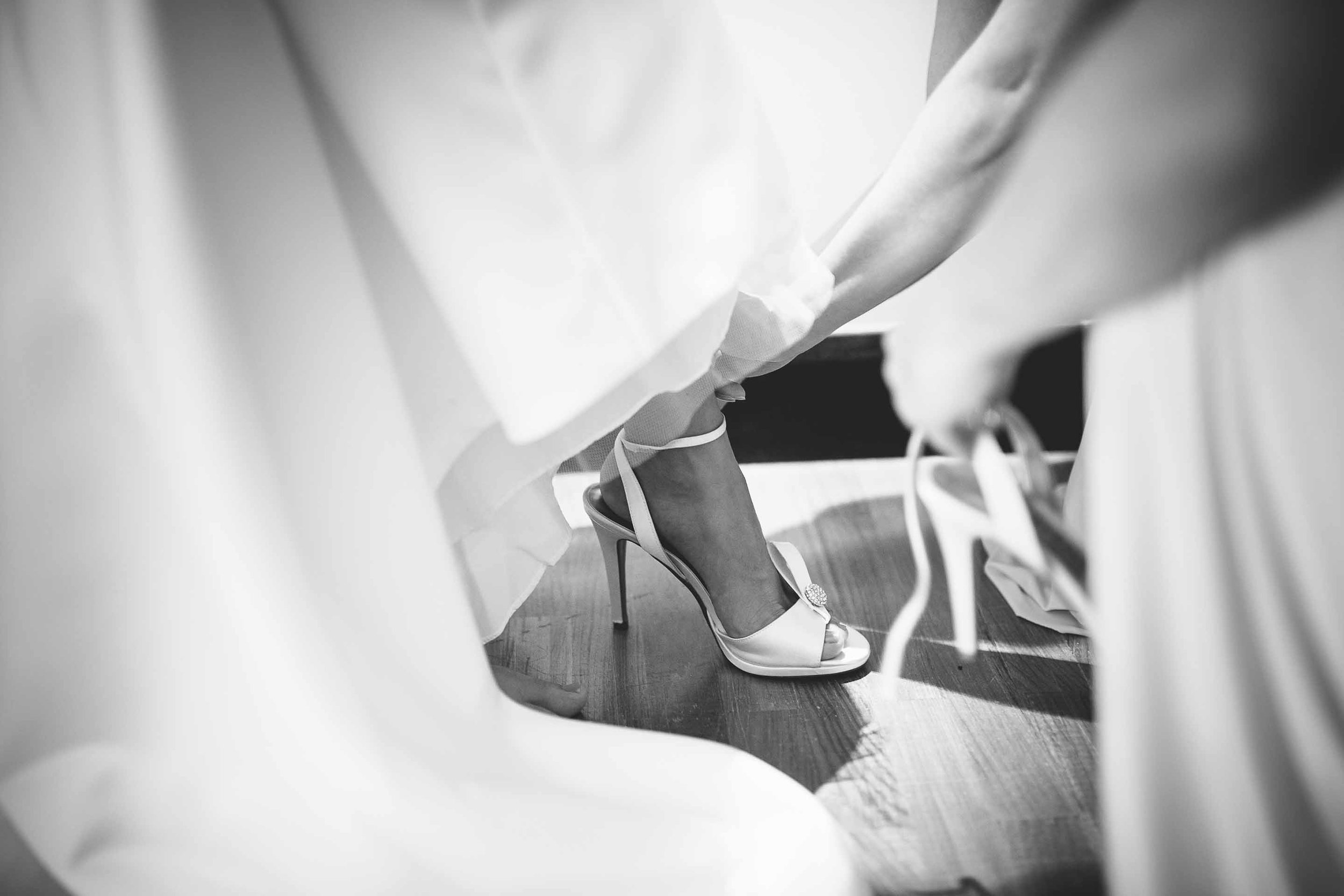 the brides shoes being done up