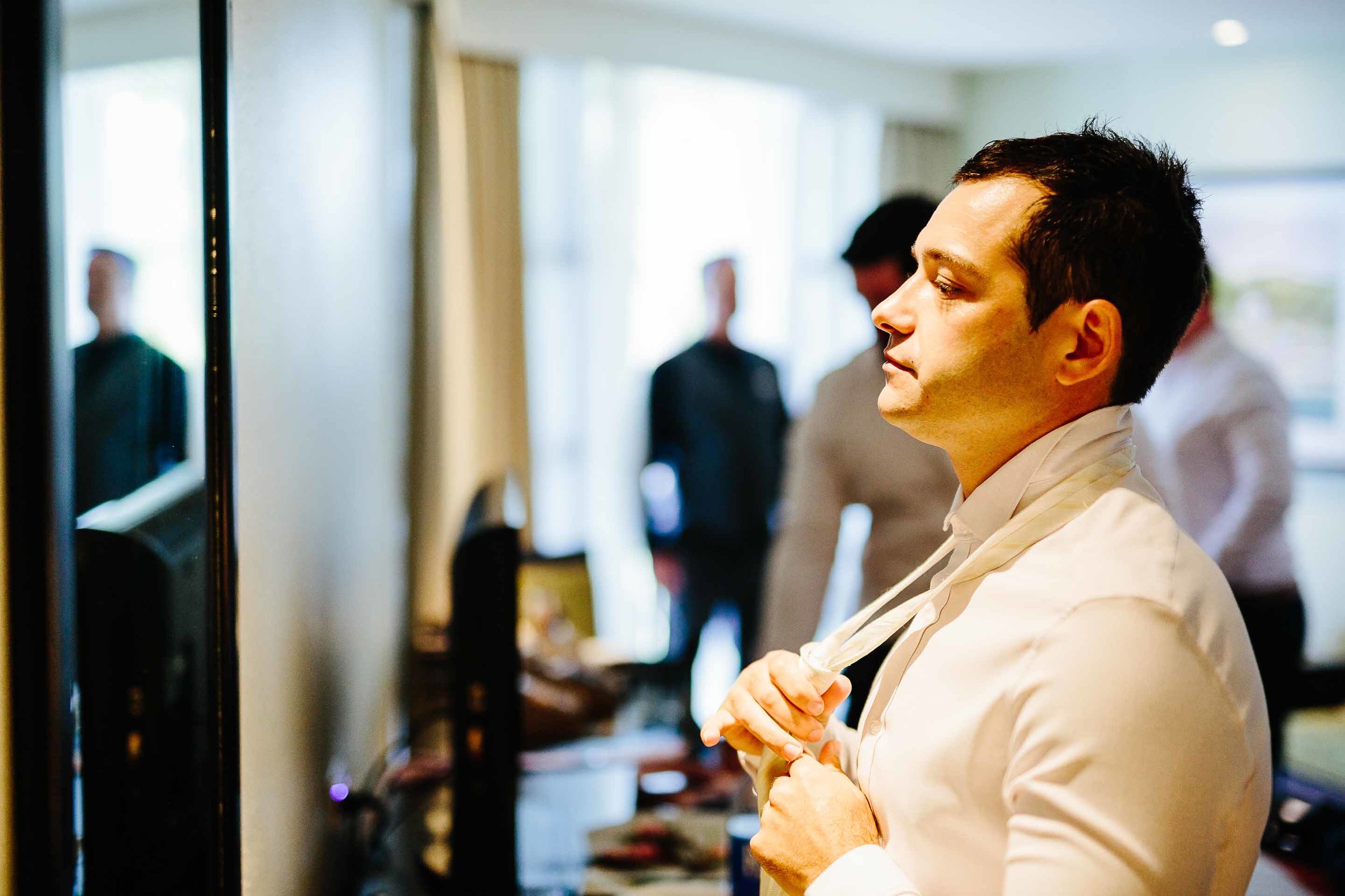 groom putting on his tie