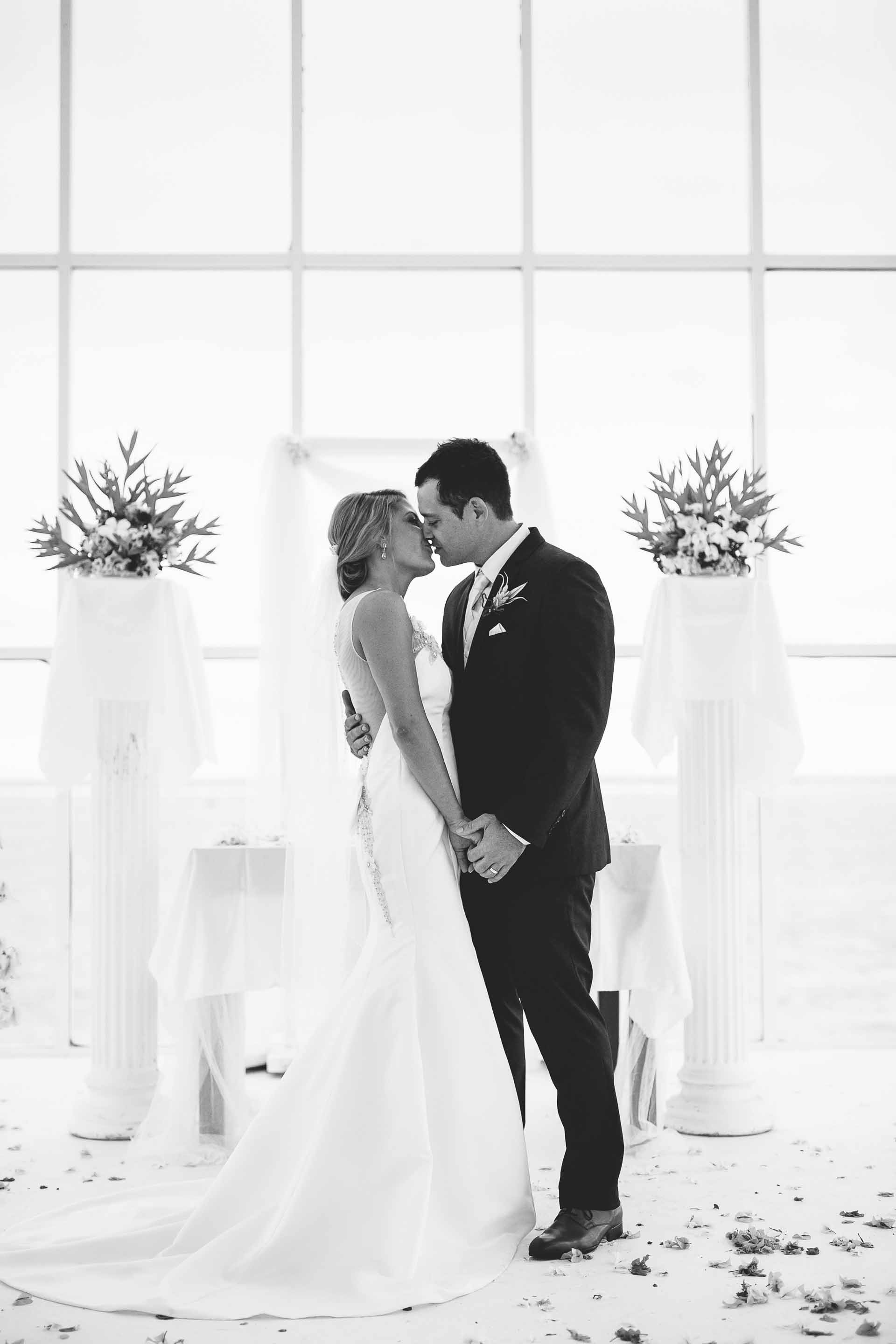 bride and groom kissing in chapel black &amp; white