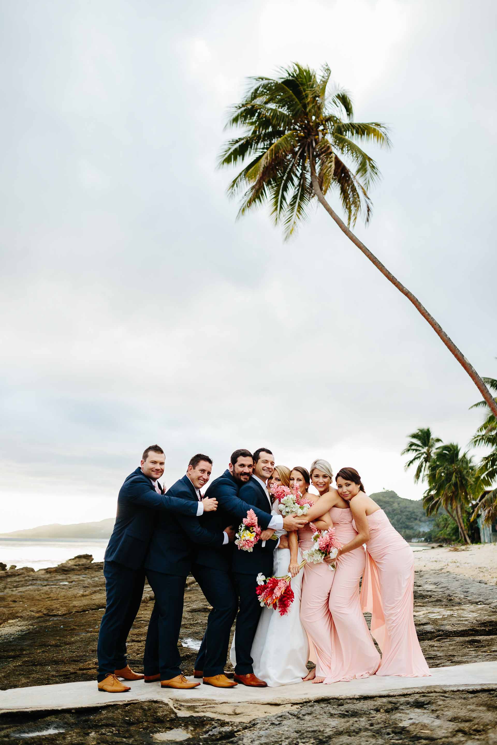 bridal party hugging on the beach