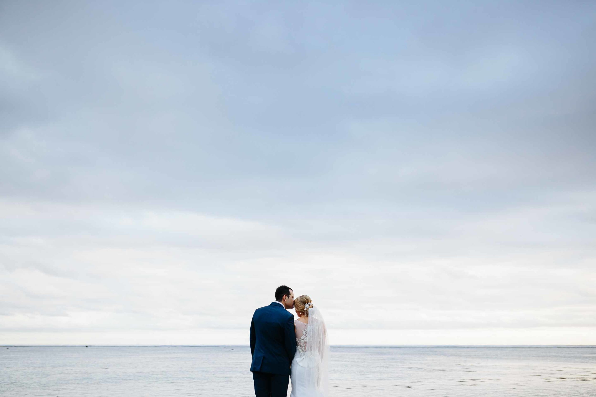 couple with cloudy sky behind them