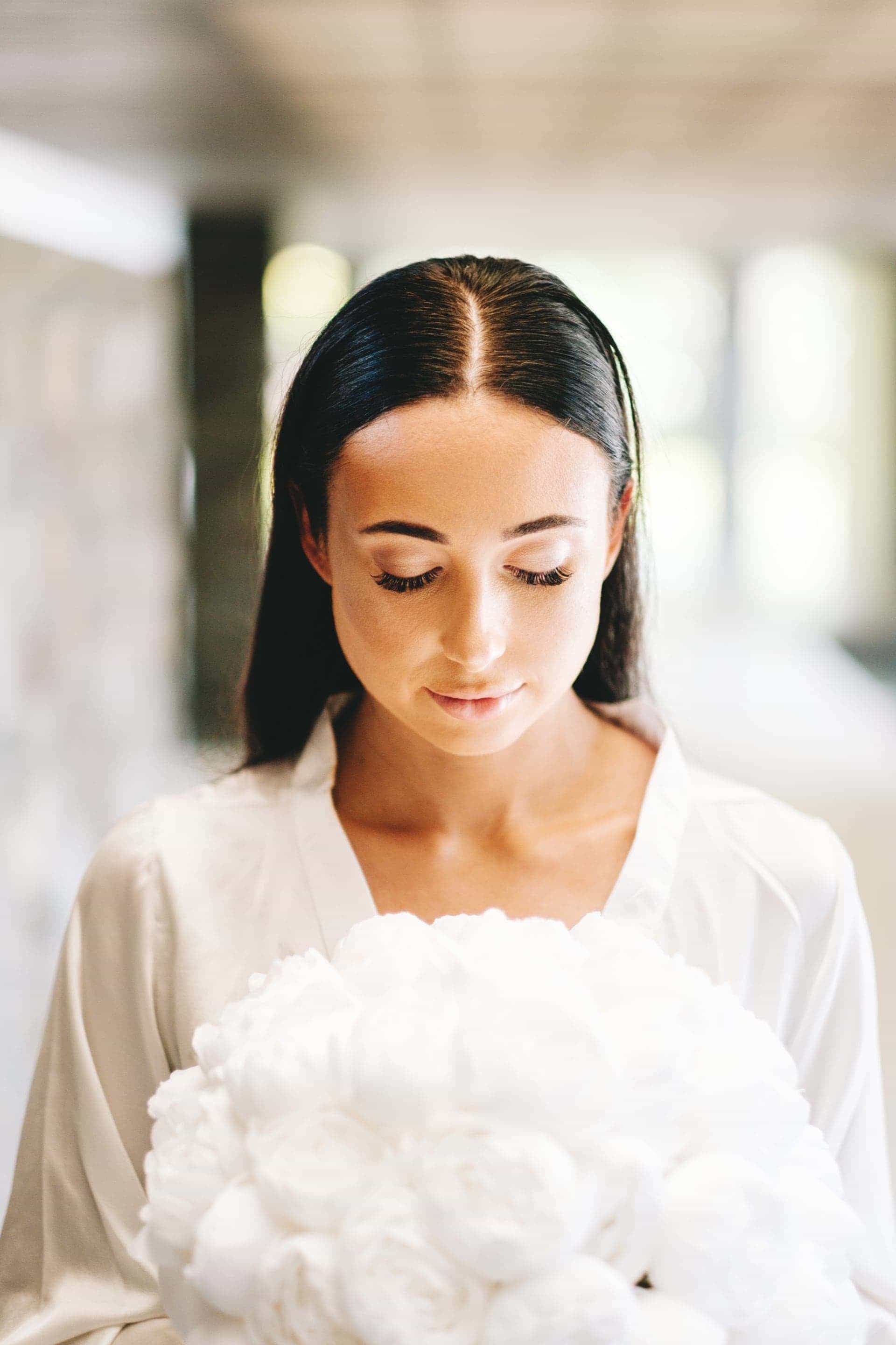the bride posing for a photo with her bouquet