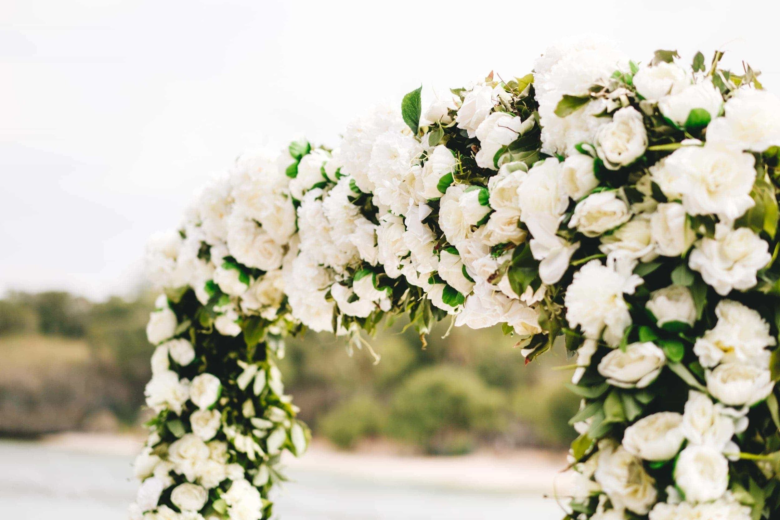 a closeup of the white rose wedding arch on the beach of the InterContinental Fiji