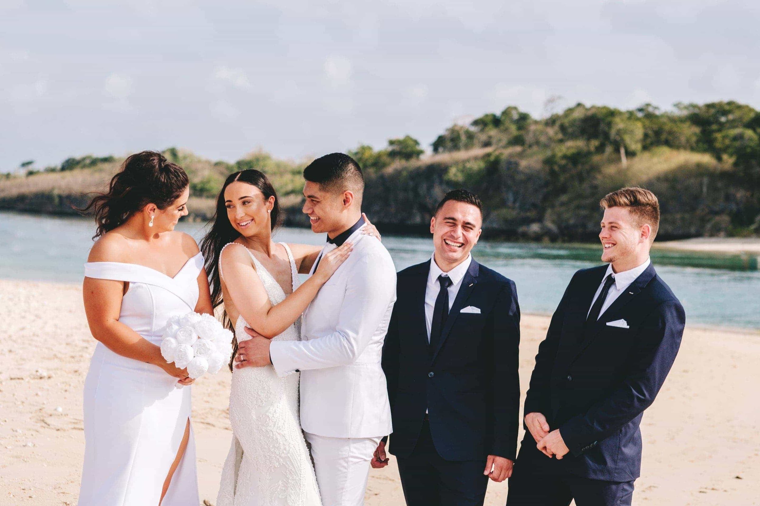 the bride and bridesmaid share a laugh as the bridal party walk along Natadola beach.