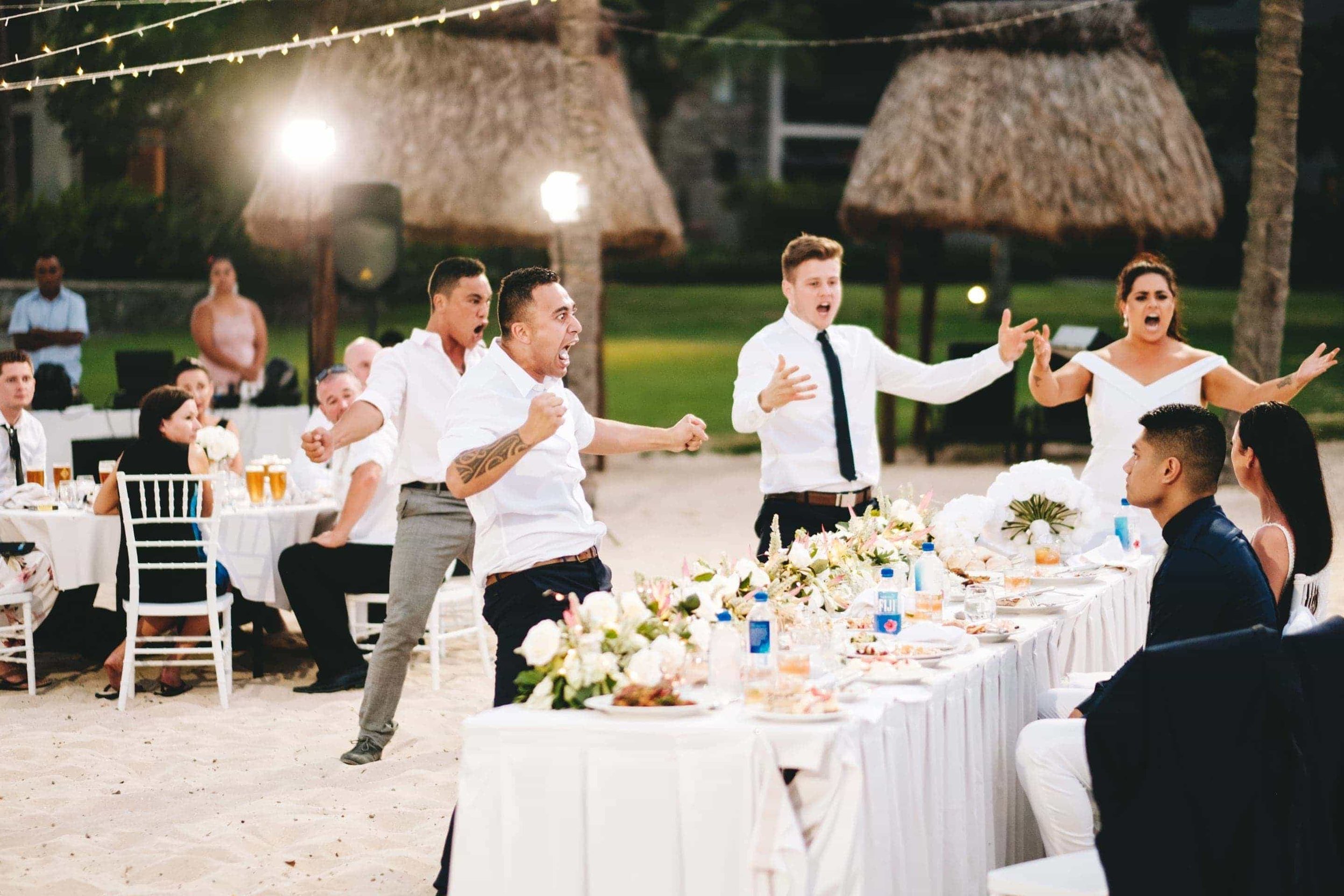 the groomsman and best man preform a traditional New Zealand Haka with guests for the wedding couple