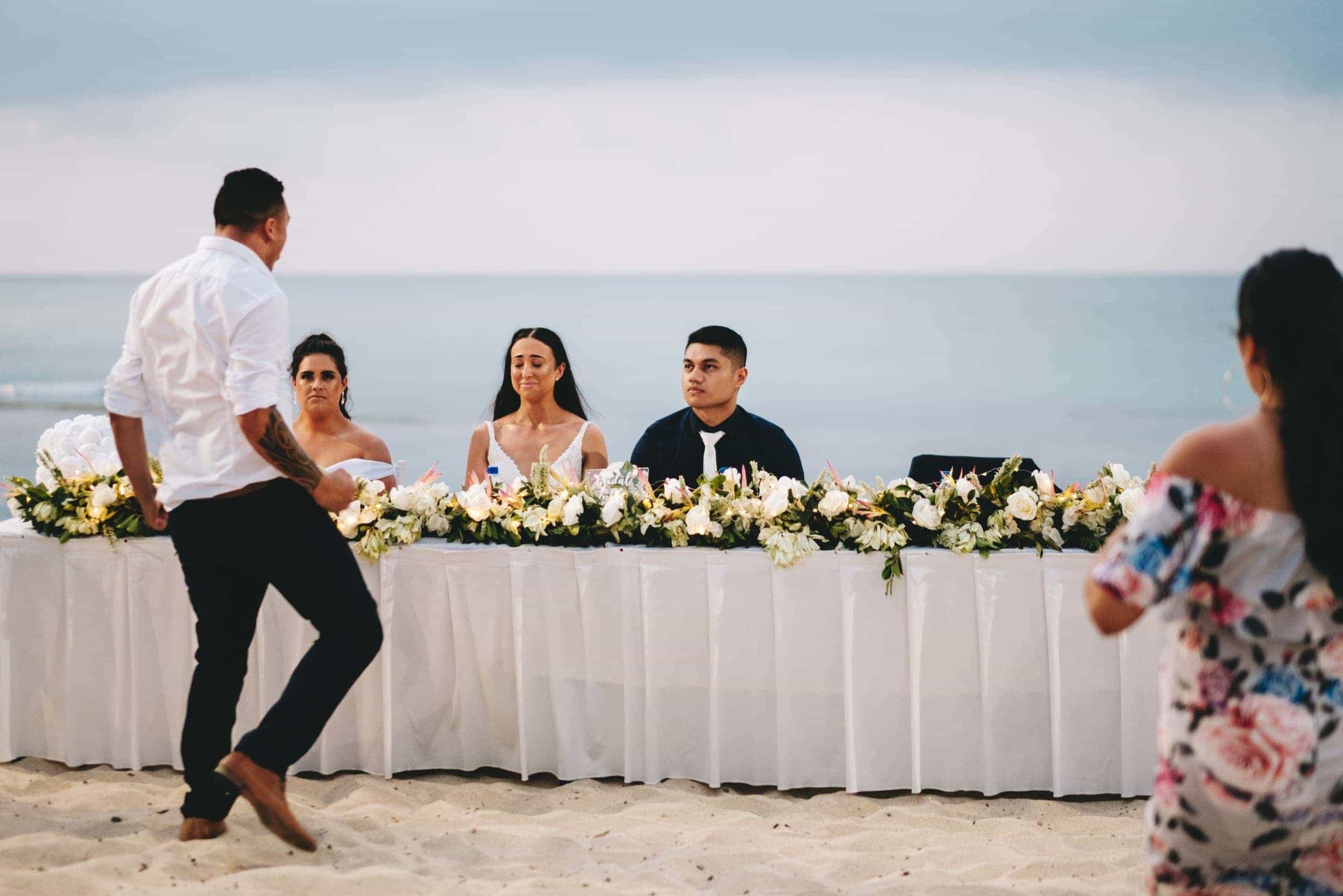 the groomsman preforming a haka to an emotional couple