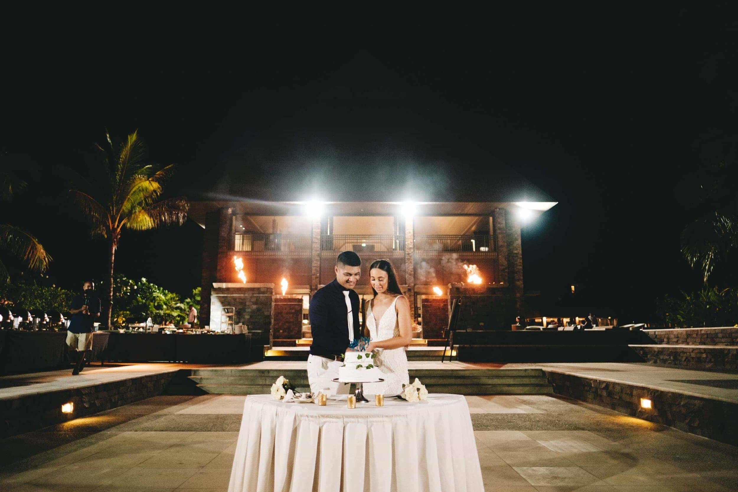 a wide photo of the bride and groom cutting their wedding cake