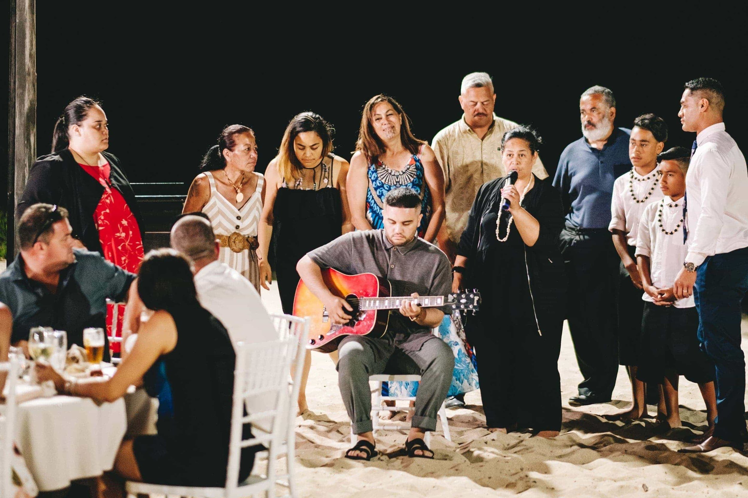 family of the groom sing a song for the couple