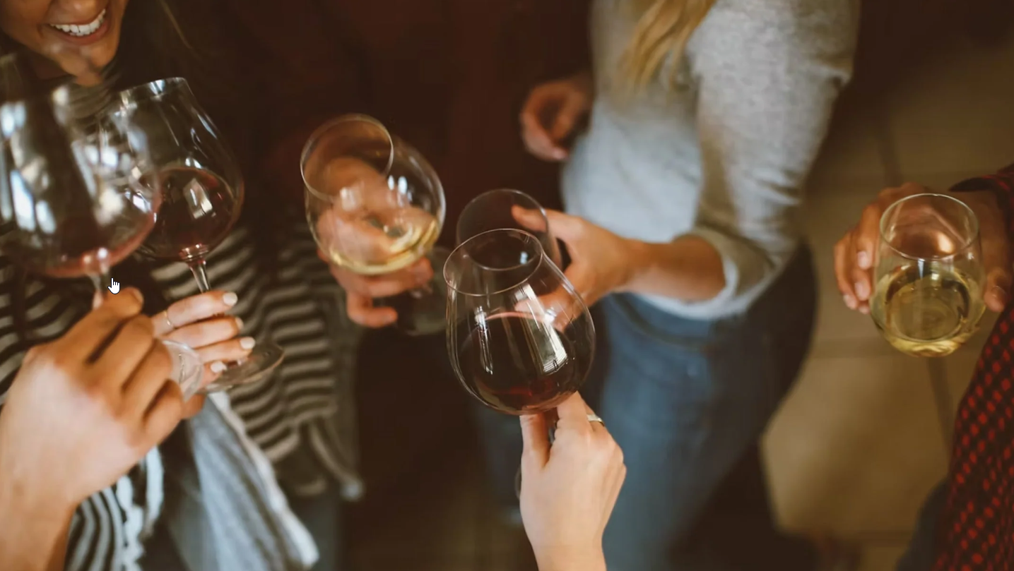 Medlemmer af vinklub skåler i vin ved månedlig vinsmagning